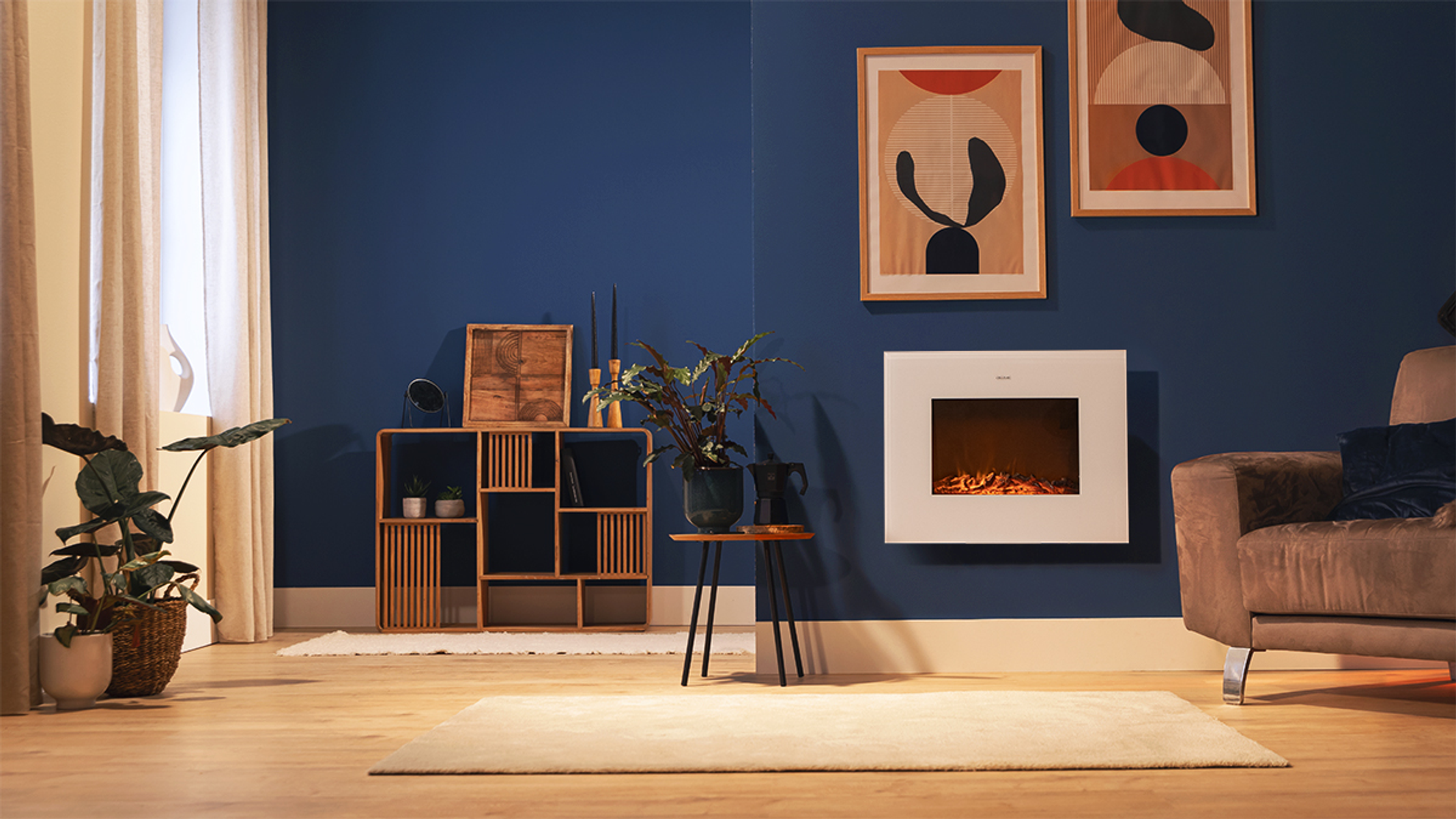 Wohnzimmer mit blauer Wand, Kunstwerken, Kamin, Pflanzen und Sofa.