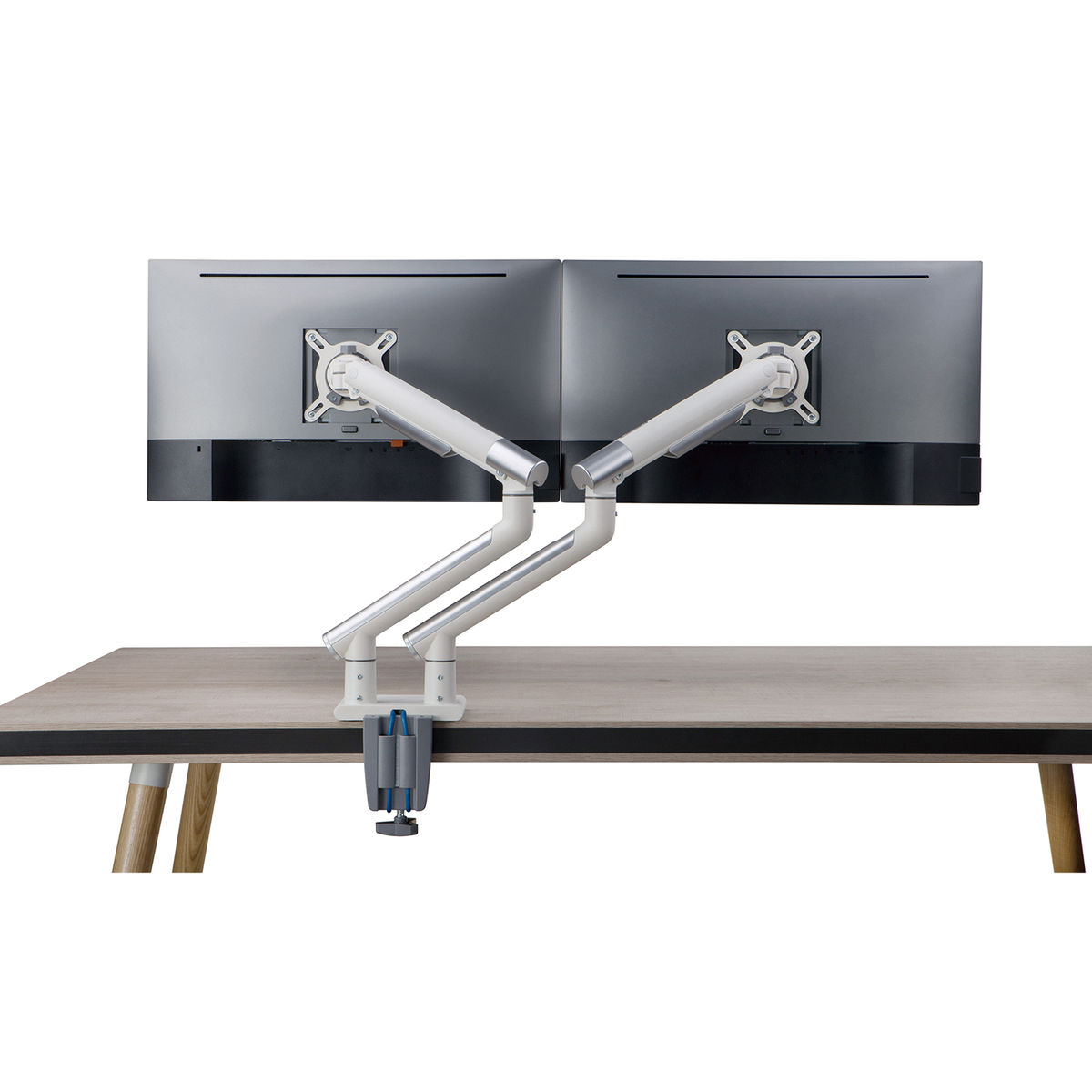 White and silver dual monitor arm mounted on a wooden desk with a white background.