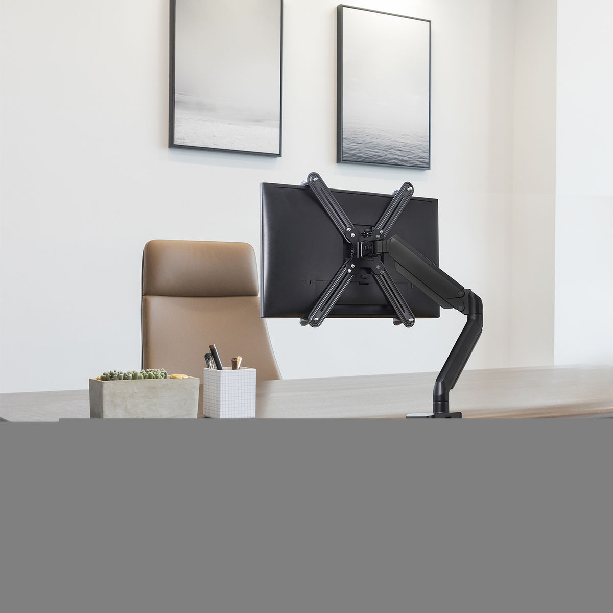 Un monitor montato su una scrivania con forniture per ufficio.