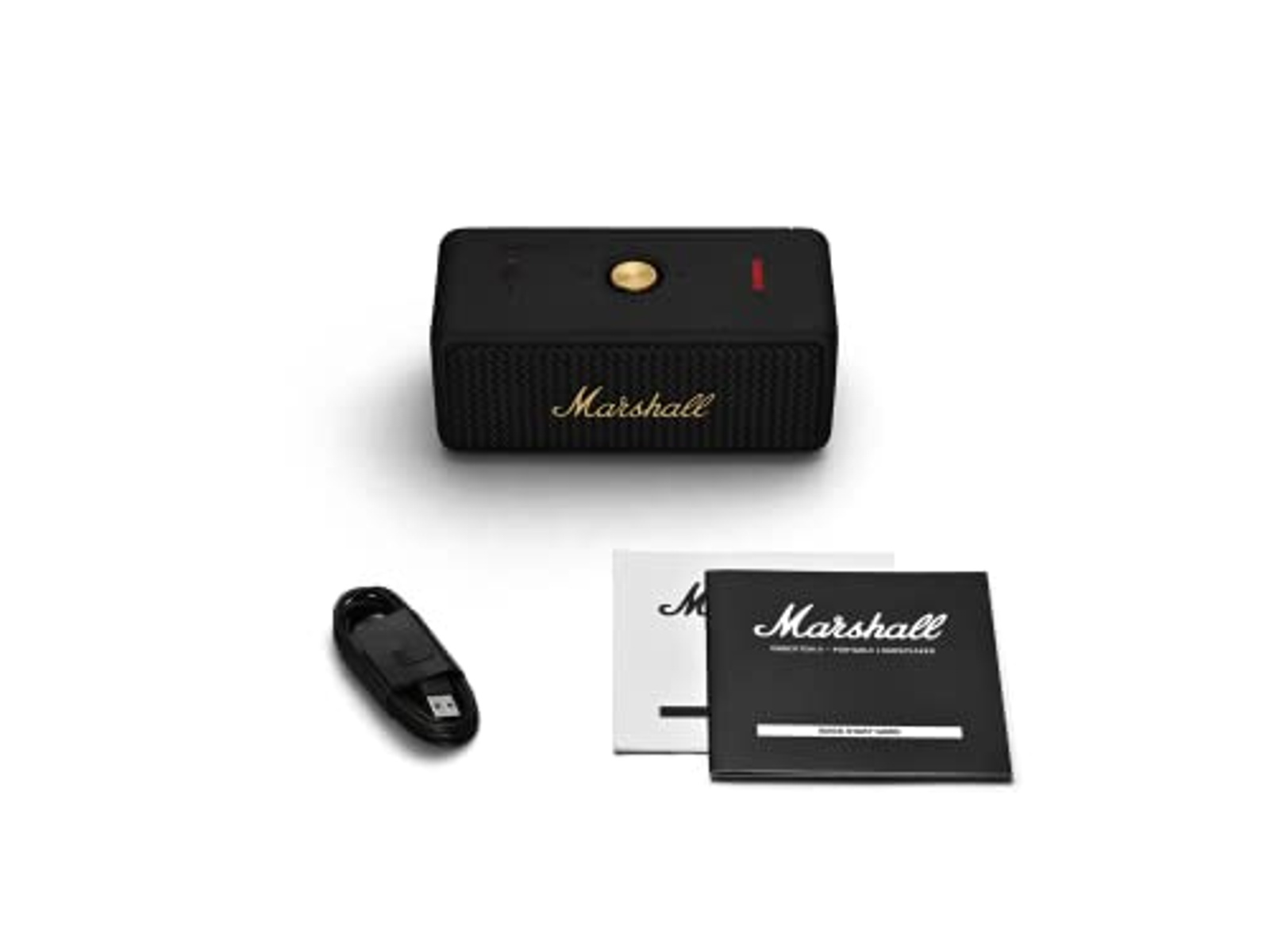 Altavoz Marshall negro, cable de carga y manuales sobre fondo blanco. Diseño moderno.