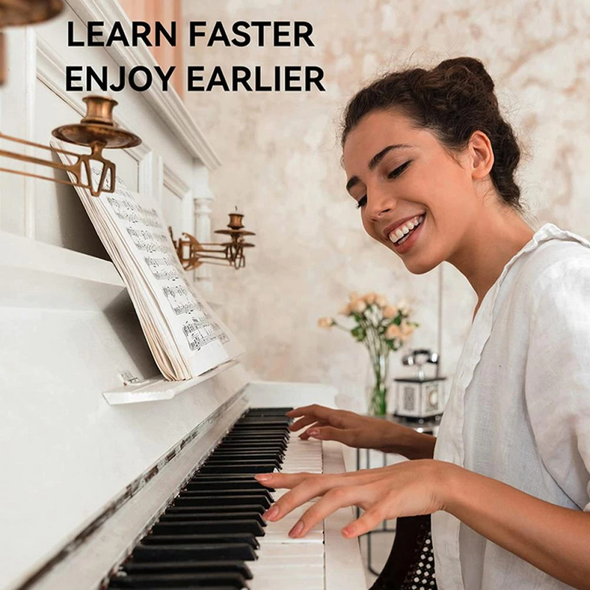 Mujer tocando el piano, piano blanco, partituras, fondo blanco.