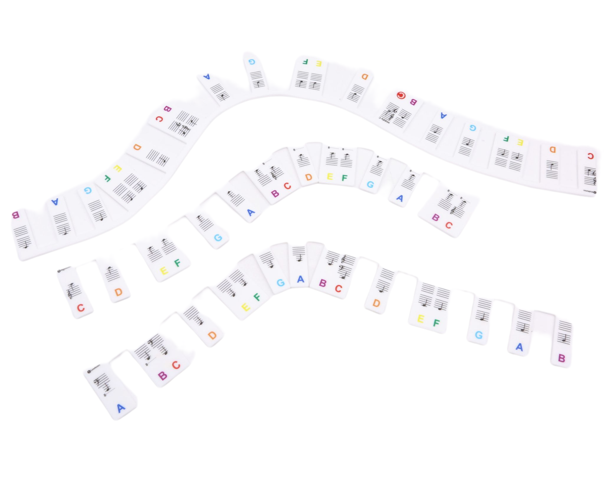 Pegatinas de teclado de piano con notas y símbolos musicales, dispuestas en filas curvas sobre una superficie blanca.