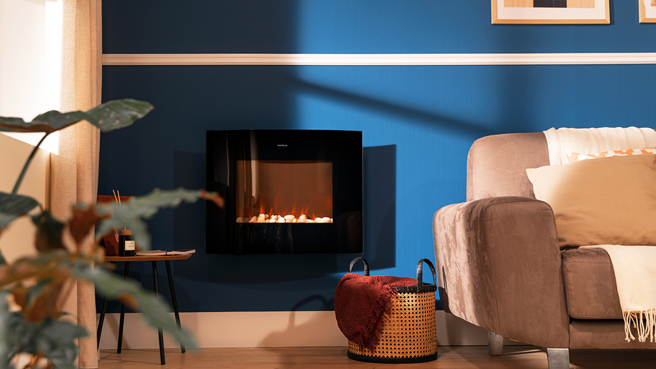 Wohnzimmer mit elektrischem Kamin. Blaue Wand, Sofa, Korb und ein Fenster.