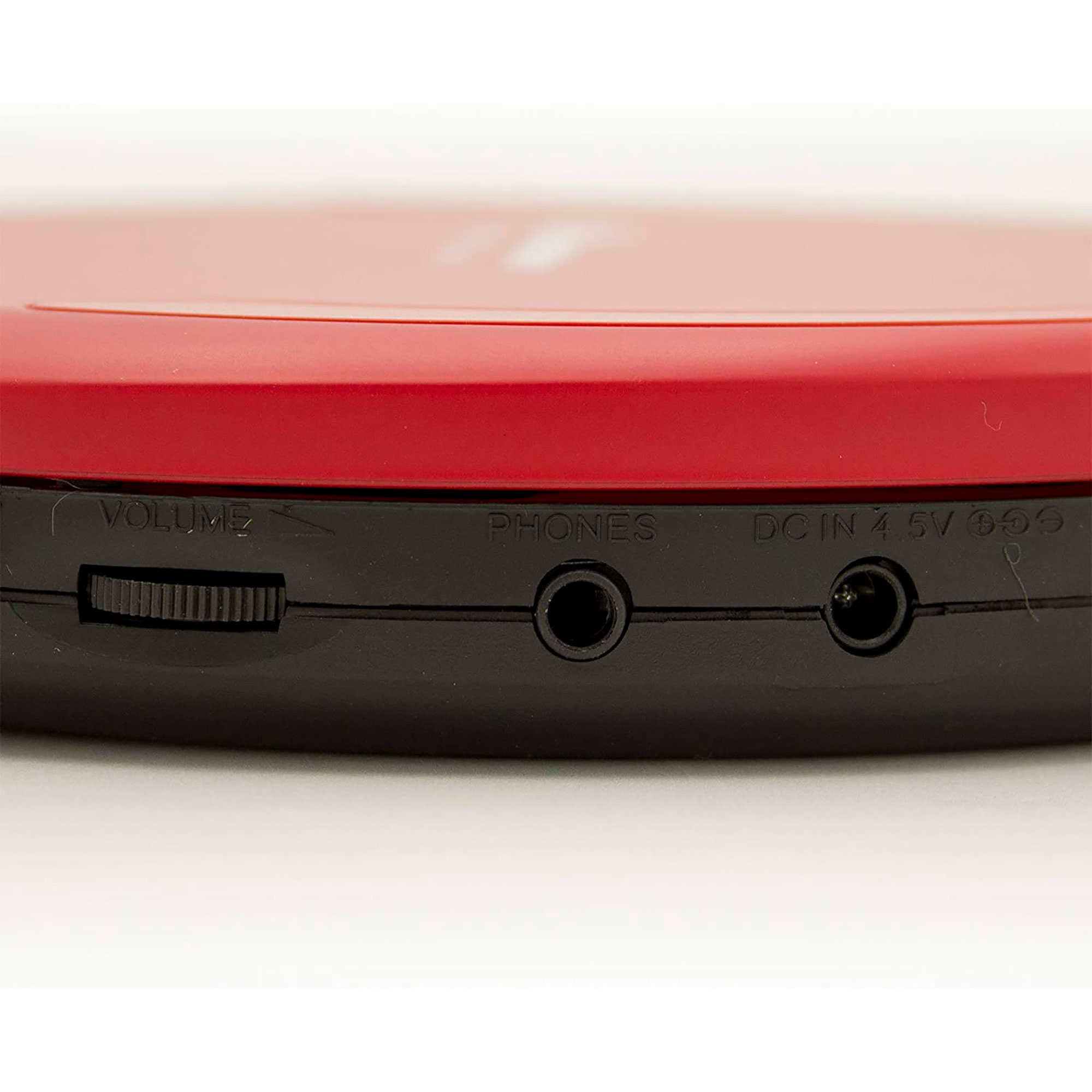 Reproductor de CD portátil rojo y negro. Tiene puertos de volumen, teléfono y CC.