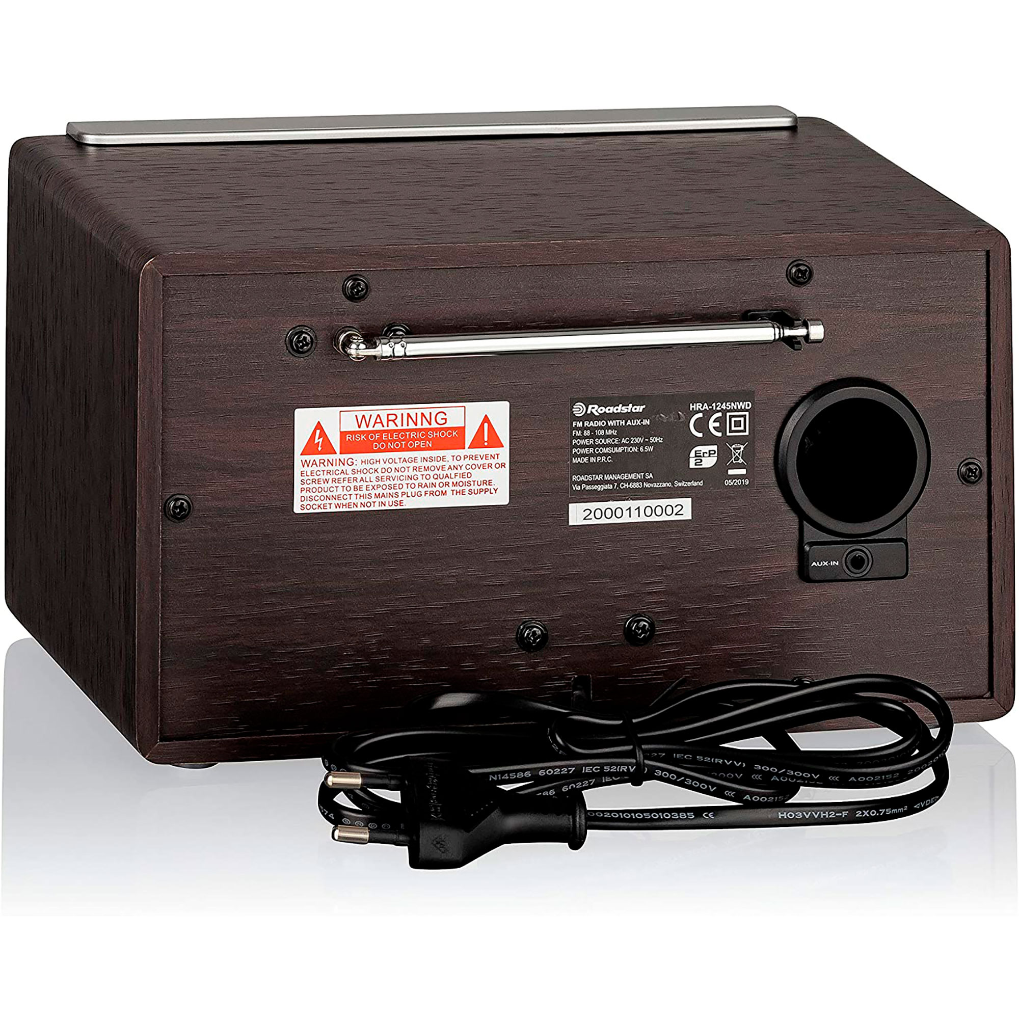 Ciemne drewniane radio retro na białej powierzchni, z etykietą ostrzegawczą.