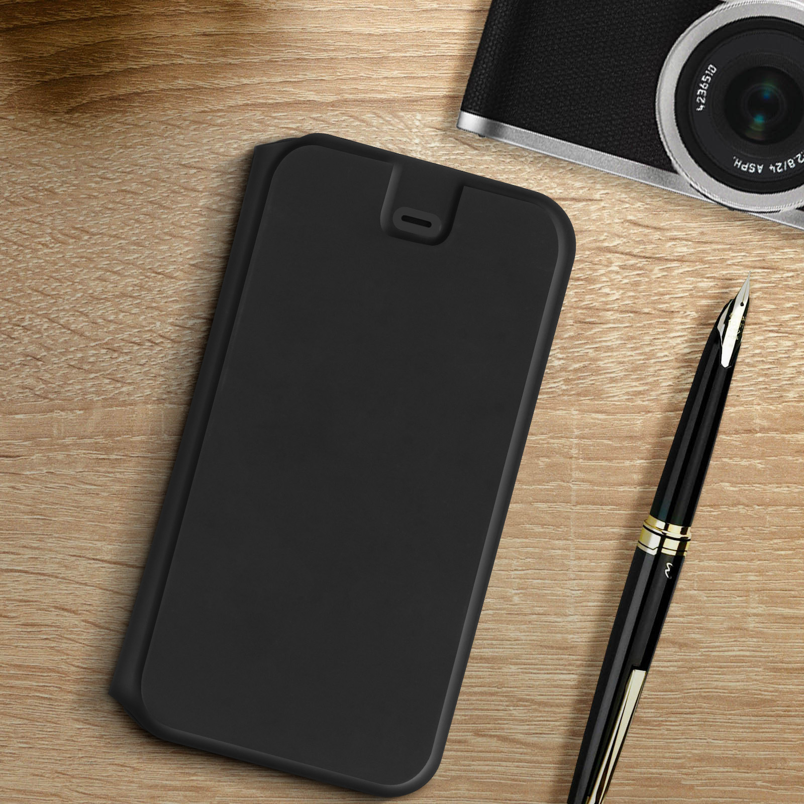 Una custodia per telefono nera con un ritaglio per la fotocamera, accanto a una penna su una scrivania di legno.