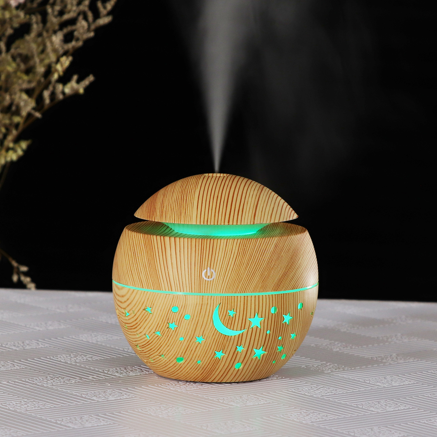 Aroma-Diffusor aus Holz. Helle Holzmaserung. Sterne und Mond-Ausschnitte. Nebel emittierend.