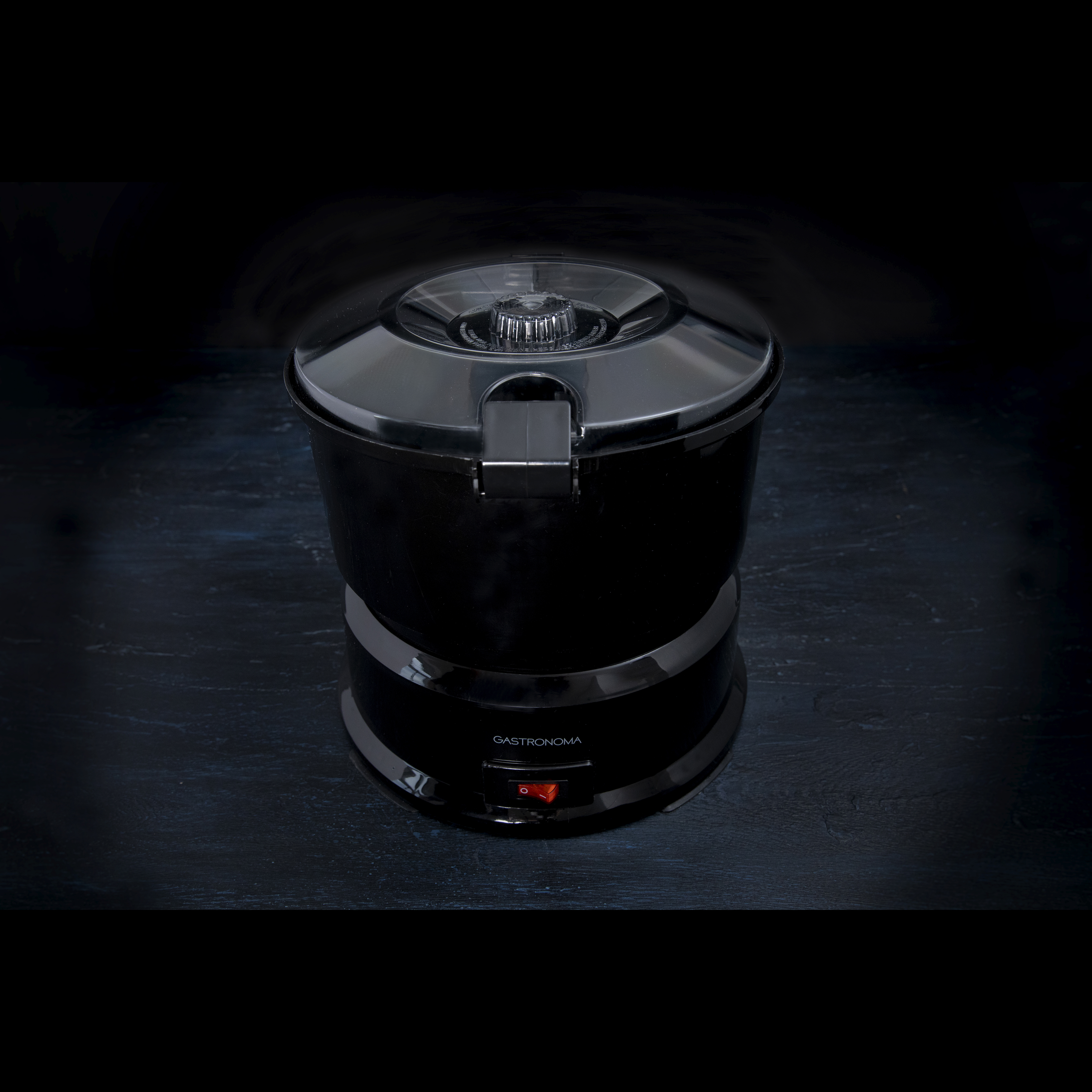 Czarna frytkownica na ciemnej powierzchni z czerwonym wskaźnikiem zasilania.