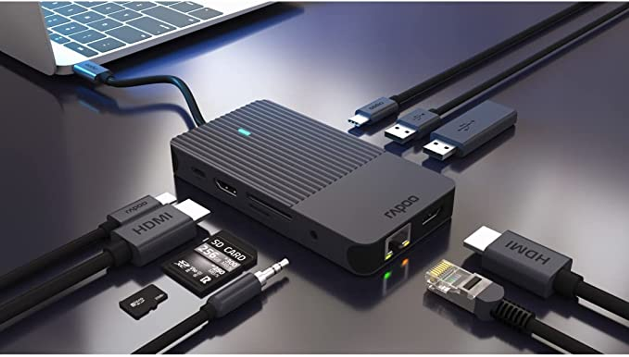 Un concentrador negro con varios puertos y cables está conectado a una laptop a través de un cable azul.