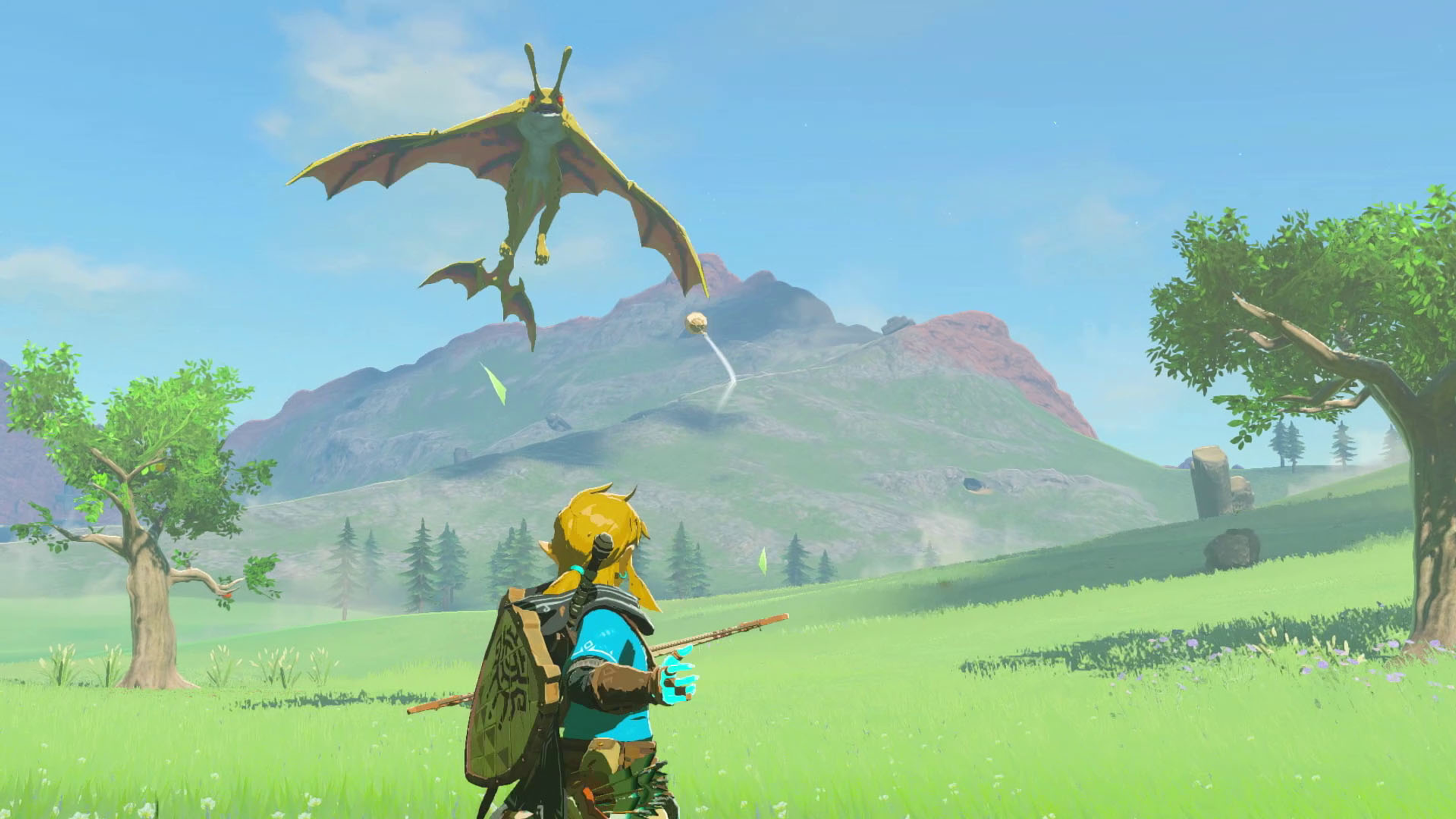 Eine Spielfigur, die mit einem Bogen auf eine fliegende Kreatur zielt, grüne Landschaft.