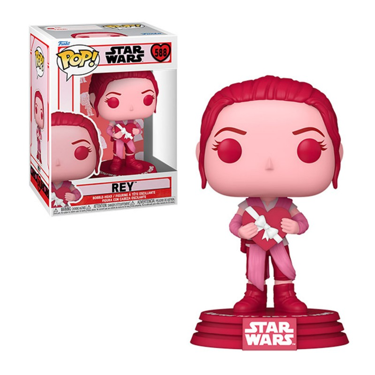 Una statuetta Star Wars Rey Funko Pop con un cuore, esposta su un supporto, con una scatola sullo sfondo.