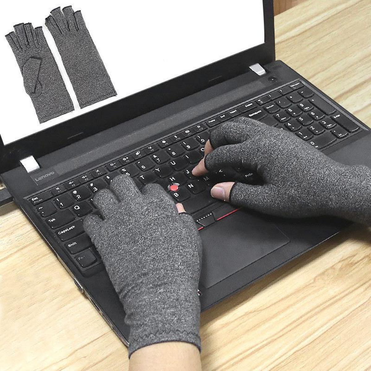 Hände mit grauen Kompressionshandschuhen tippen auf einer Laptop-Tastatur.