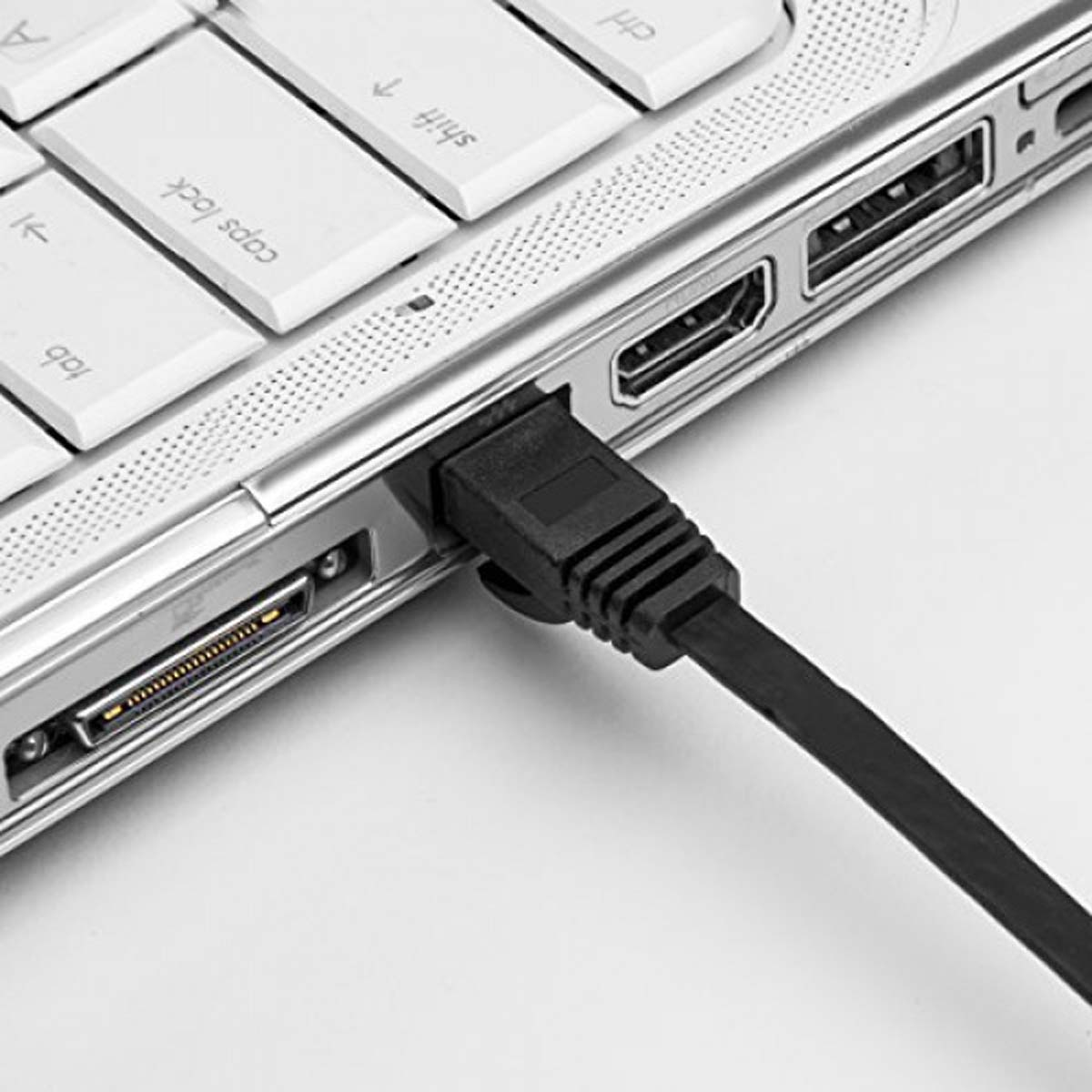 Ein schwarzes Ladekabel ist in den seitlichen Anschluss eines silbernen Laptops eingesteckt.