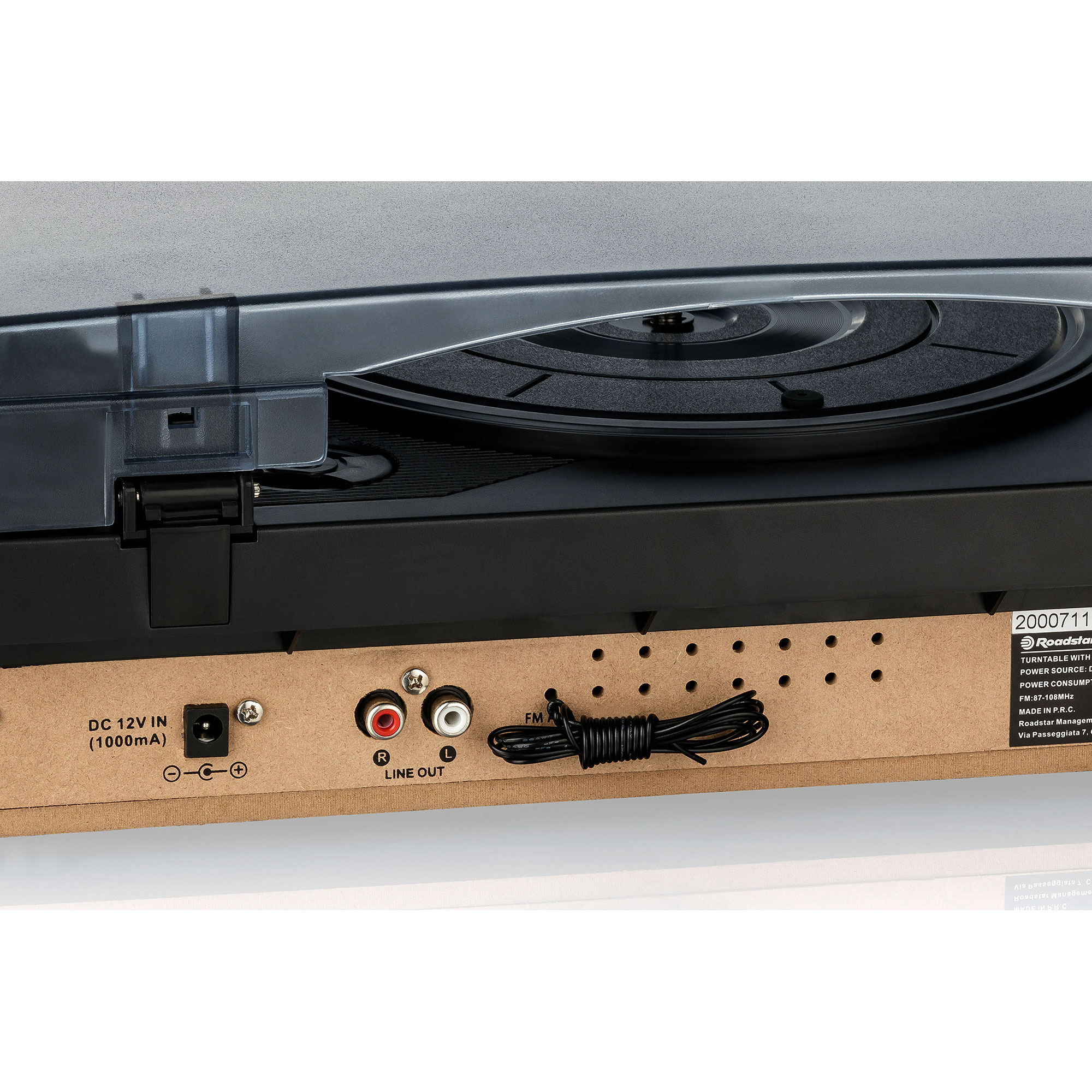 Vista trasera de un tocadiscos con puertos de salida de CC y de línea. Un cable negro con una etiqueta es visible.