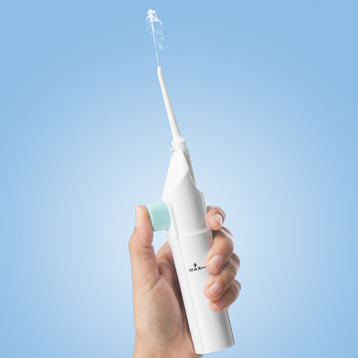 Die Hand einer Person, die einen weißen Wasser-Flosser hält, Wasser spritzt aus der Spitze.
