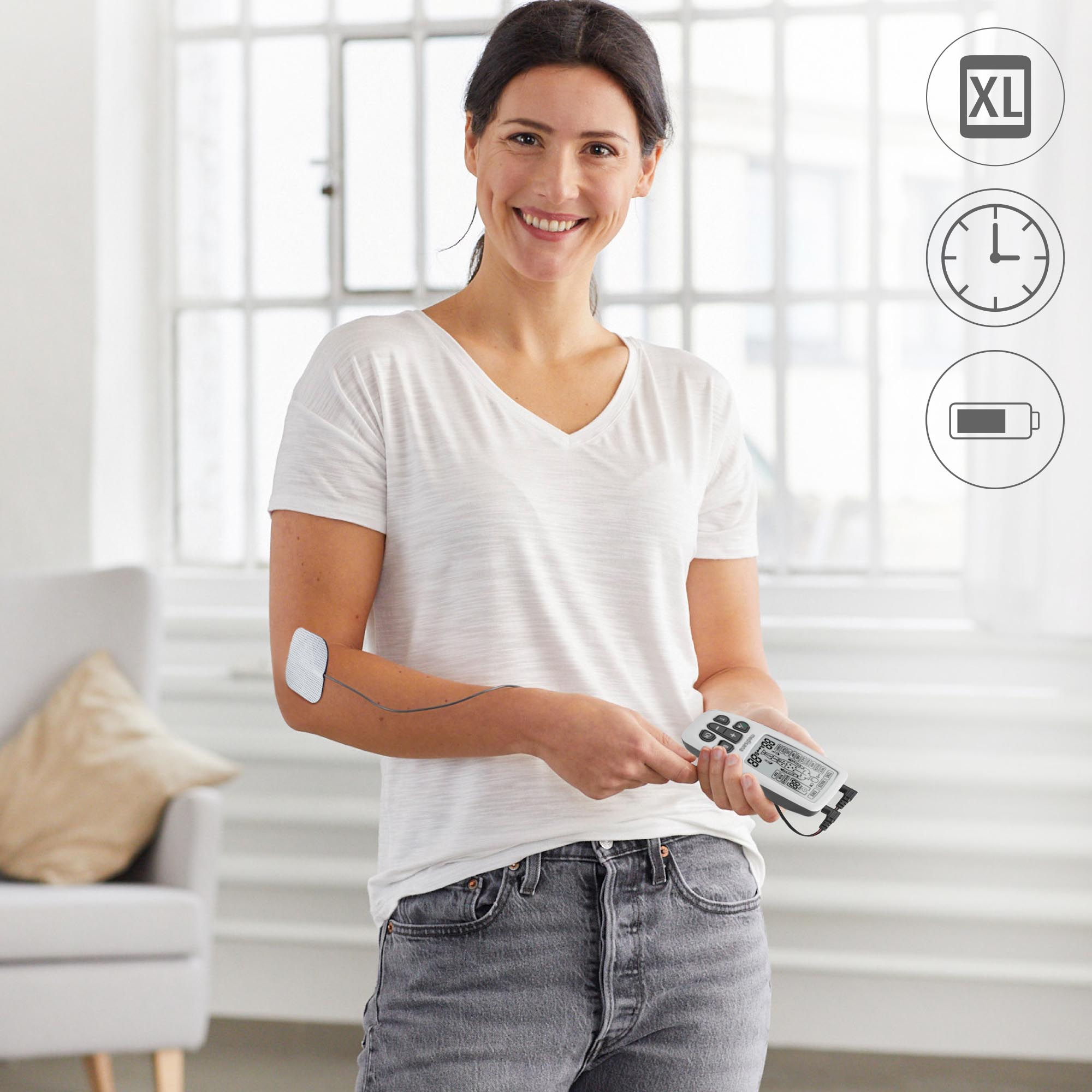 Mujer sosteniendo un dispositivo conectado a una almohadilla en su brazo. Iconos XL, tiempo y batería.