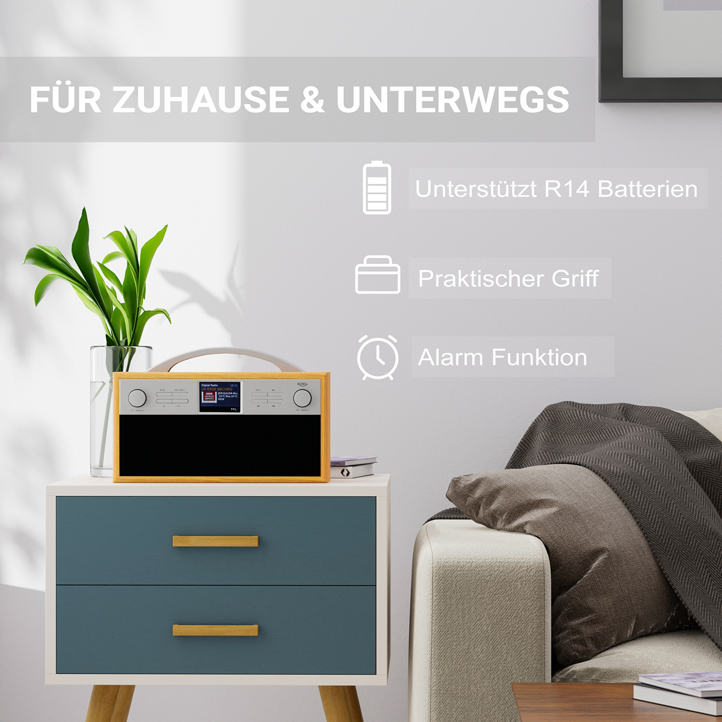 Ein Holzradio mit Display steht auf einem Tisch. Text: Für Zuhause & unterwegs. Icons zeigen Batterie, Griff, Alarm.