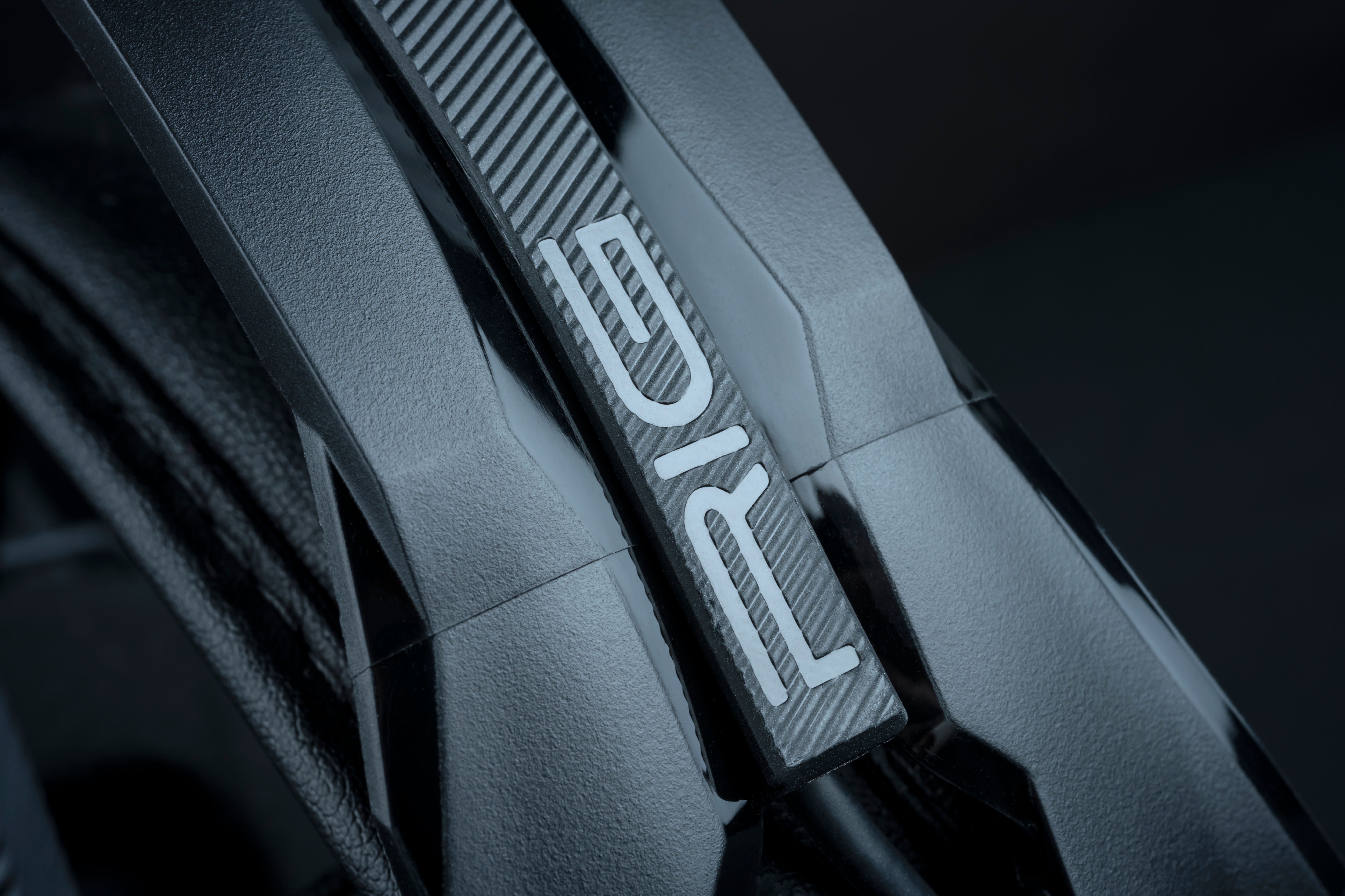 Zbliżenie czarnego obiektu ze słowem „RIG” w białych literach na teksturowanej powierzchni.