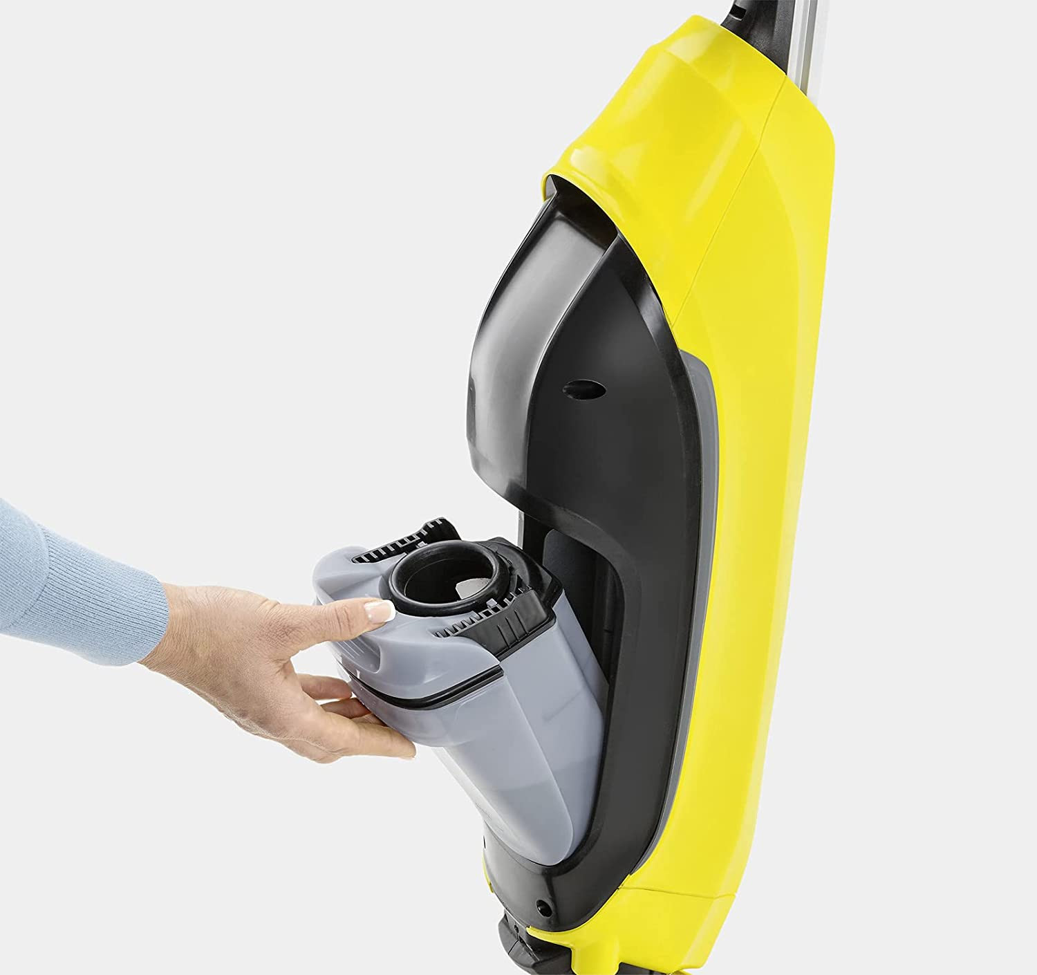 Limpiador de pisos amarillo y negro, una mano quitando el tanque de agua. Tanque gris visible.