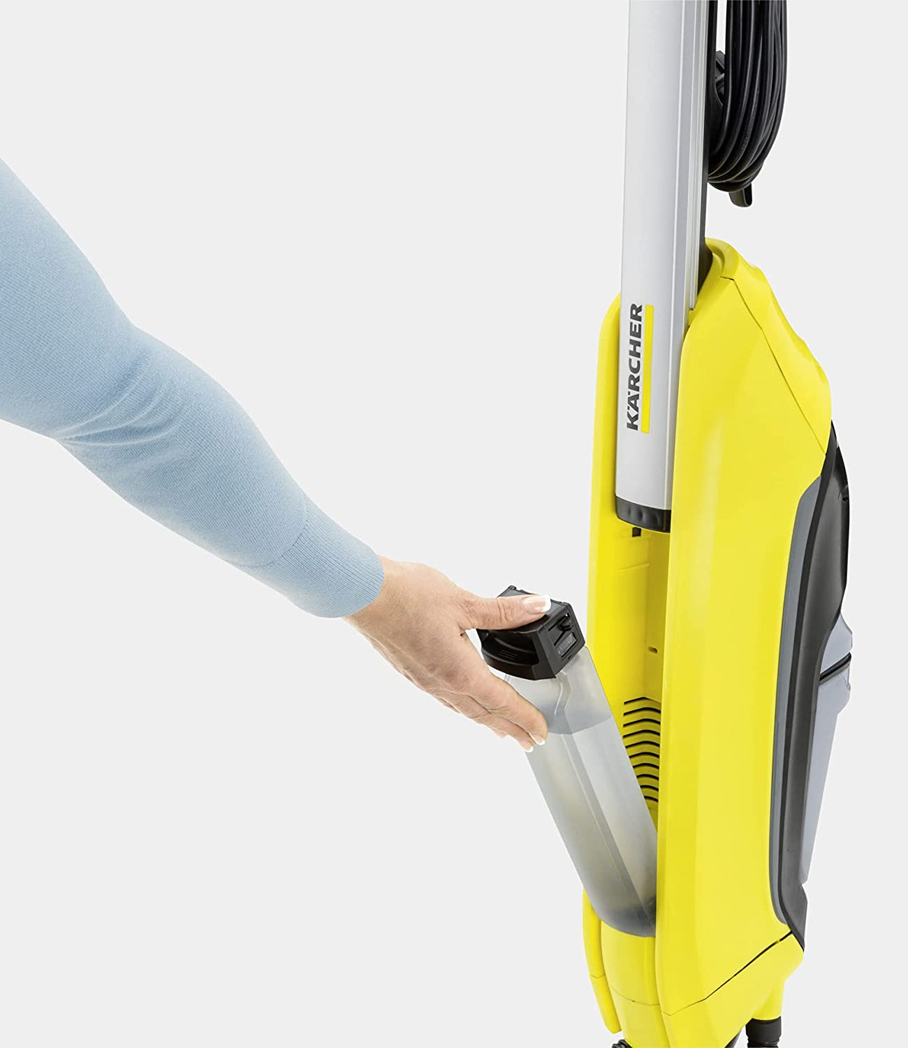 Una persona inserta un depósito de agua en una máquina de limpieza Karcher.