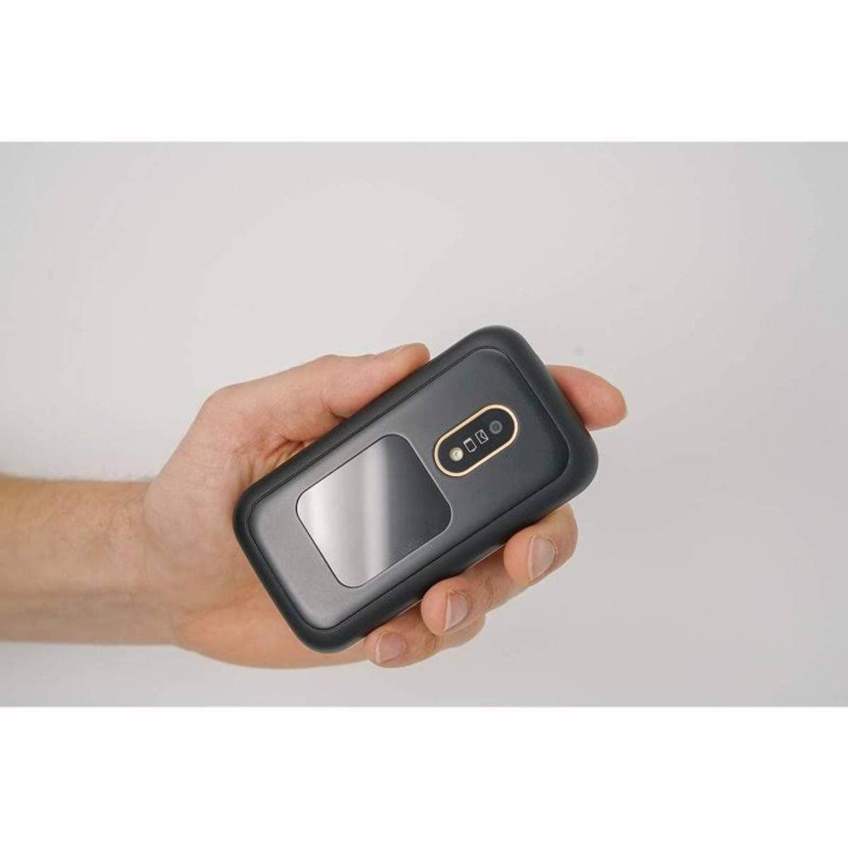 Eine Person hält ein dunkelgraues Gerät mit einem Bildschirm und zwei Knöpfen in der Hand.