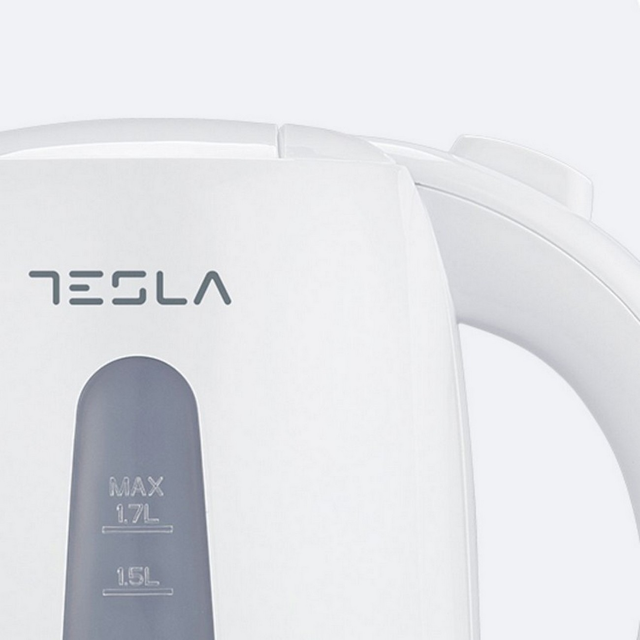 Biały czajnik elektryczny Tesla ze wskaźnikiem poziomu wody. Tekst na czajniku to Tesla.