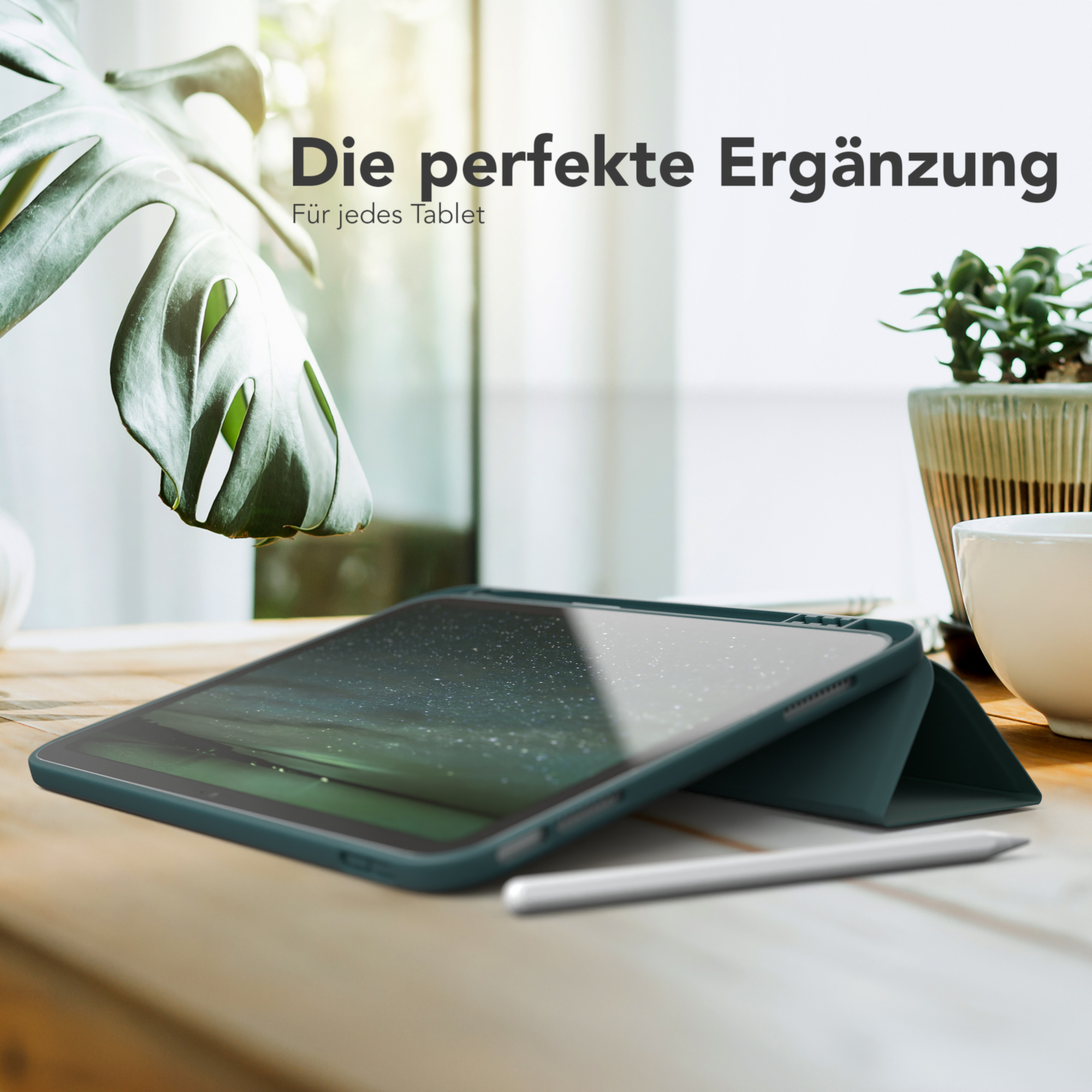 Tablet in grünem Gehäuse mit Stift auf einem Holztisch, vor einem Fenster mit natürlichem Licht.
