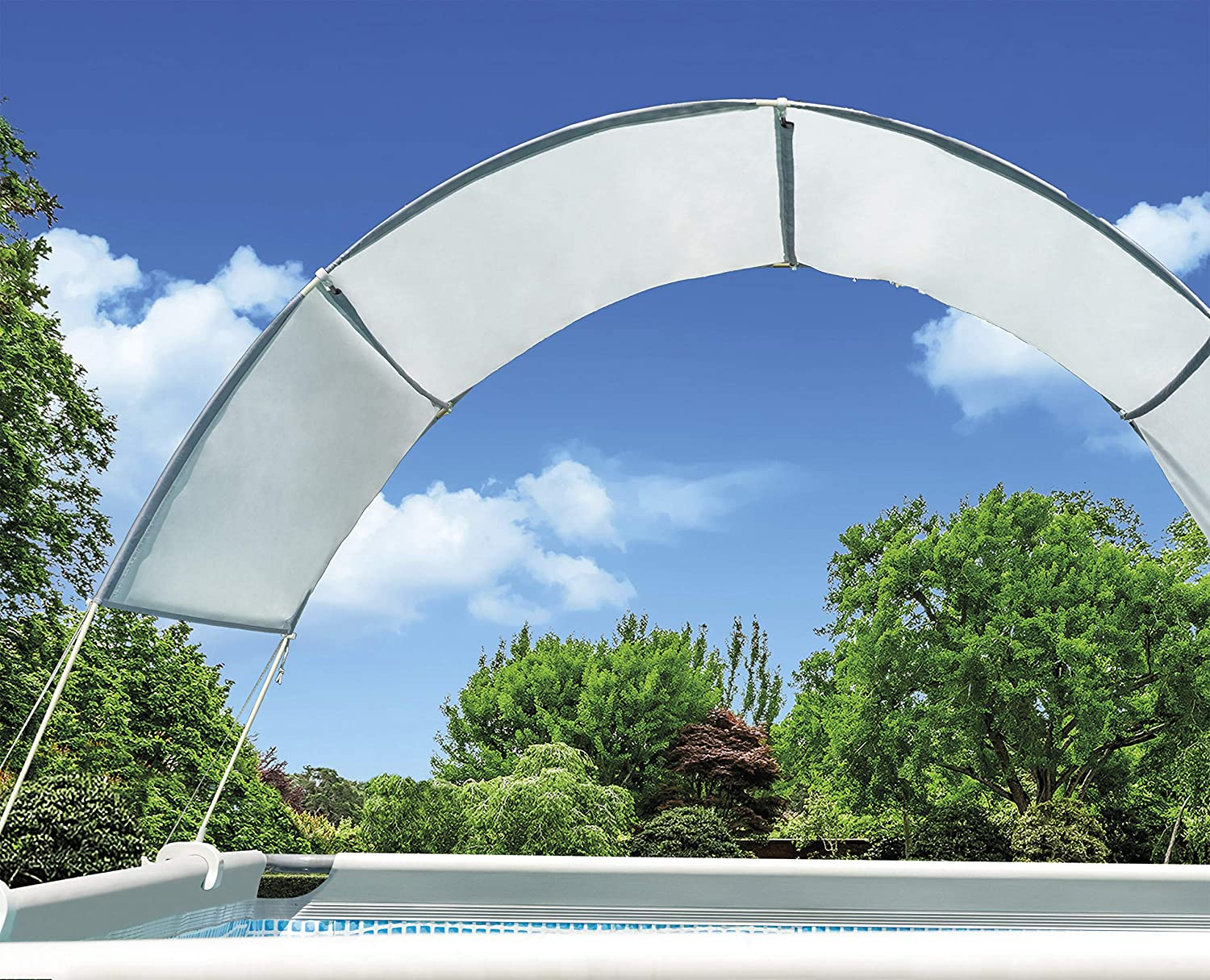 Eine weiße Poolabdeckung vor blauem Himmel mit Bäumen.