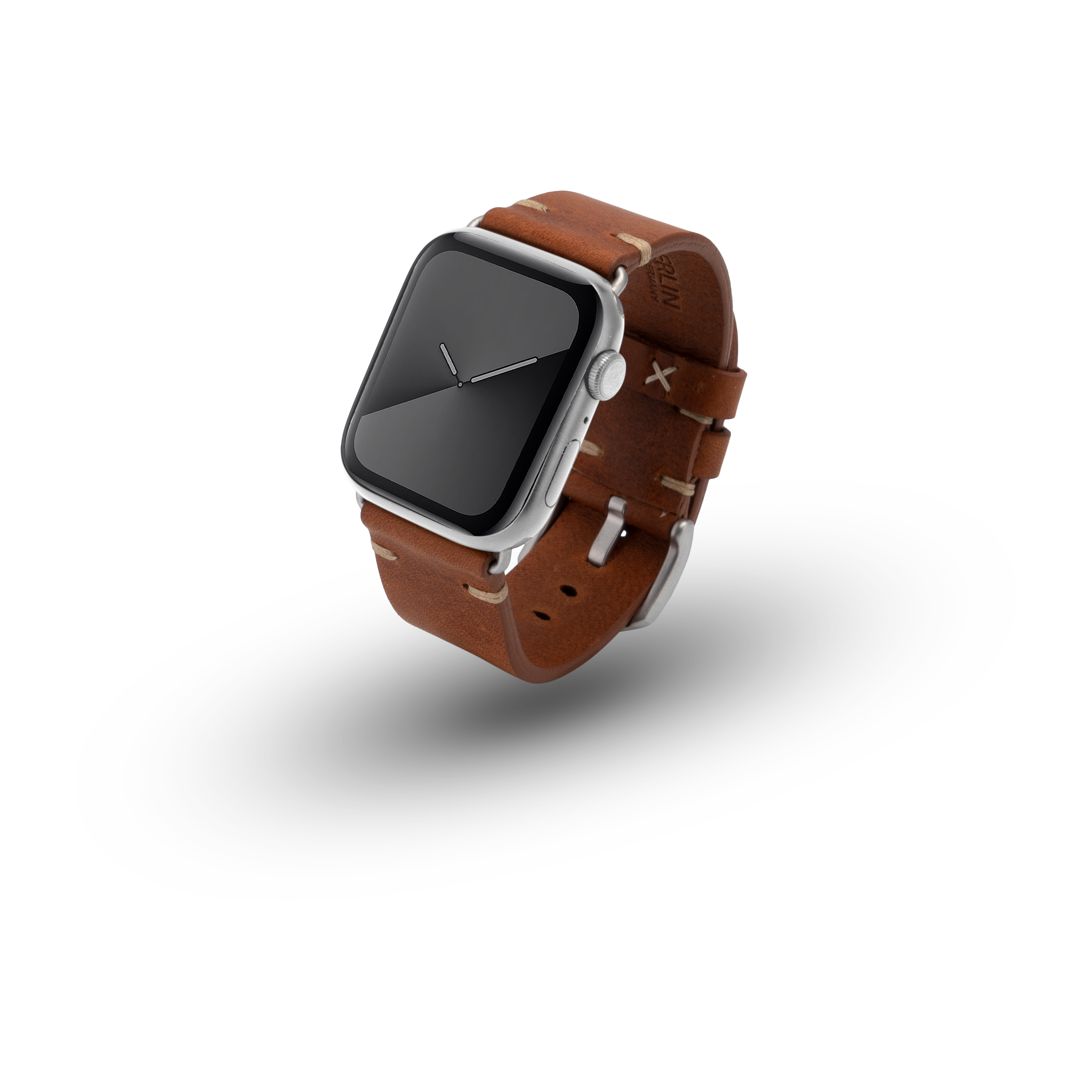 Silberne Apple Watch mit braunem Lederarmband, auf weißer Oberfläche mit Schatten.