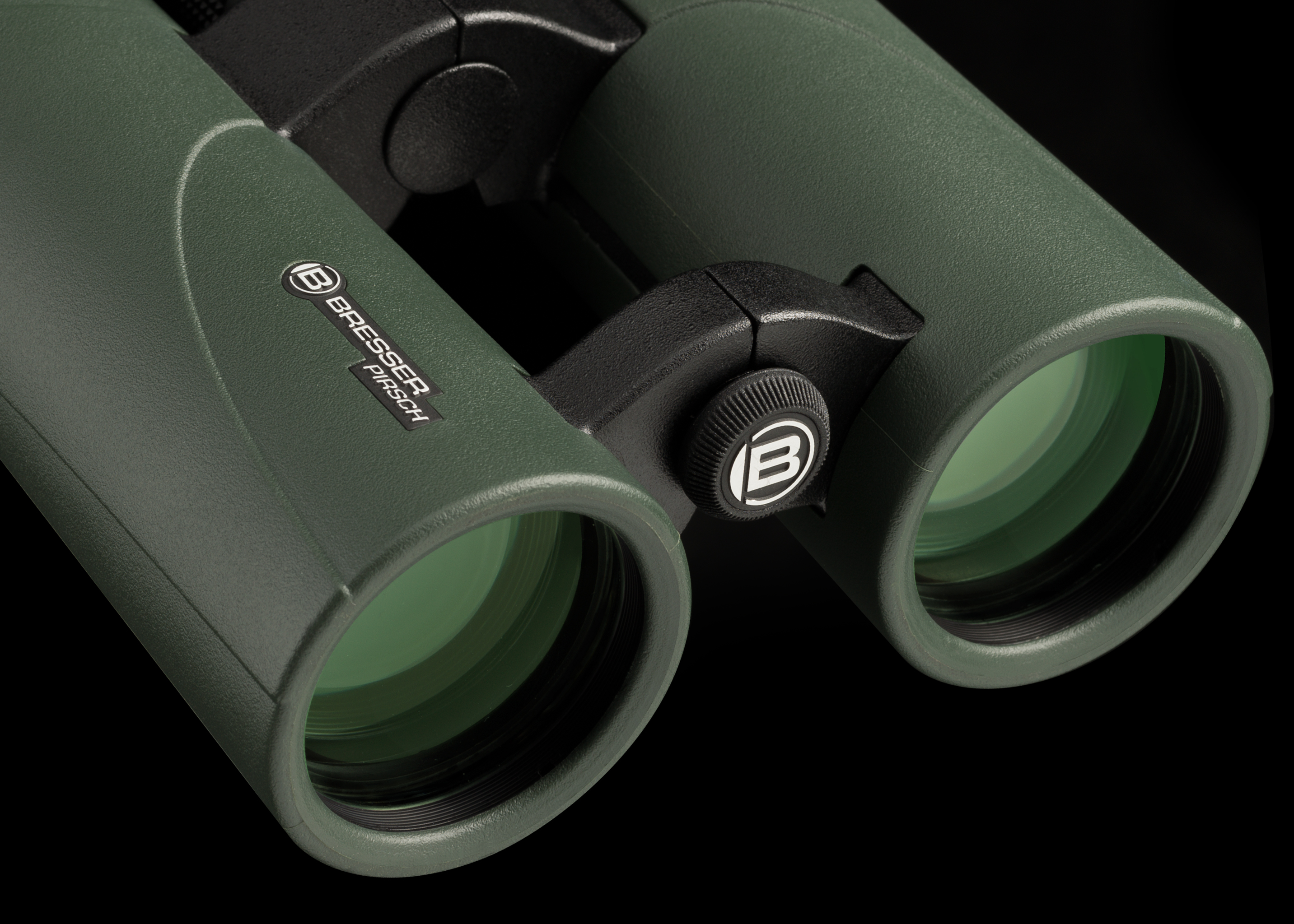Nahaufnahme eines grünen Bresser-Fernglases. Schwarzes Fokusrad in der Mitte. Schwarzer Hintergrund.