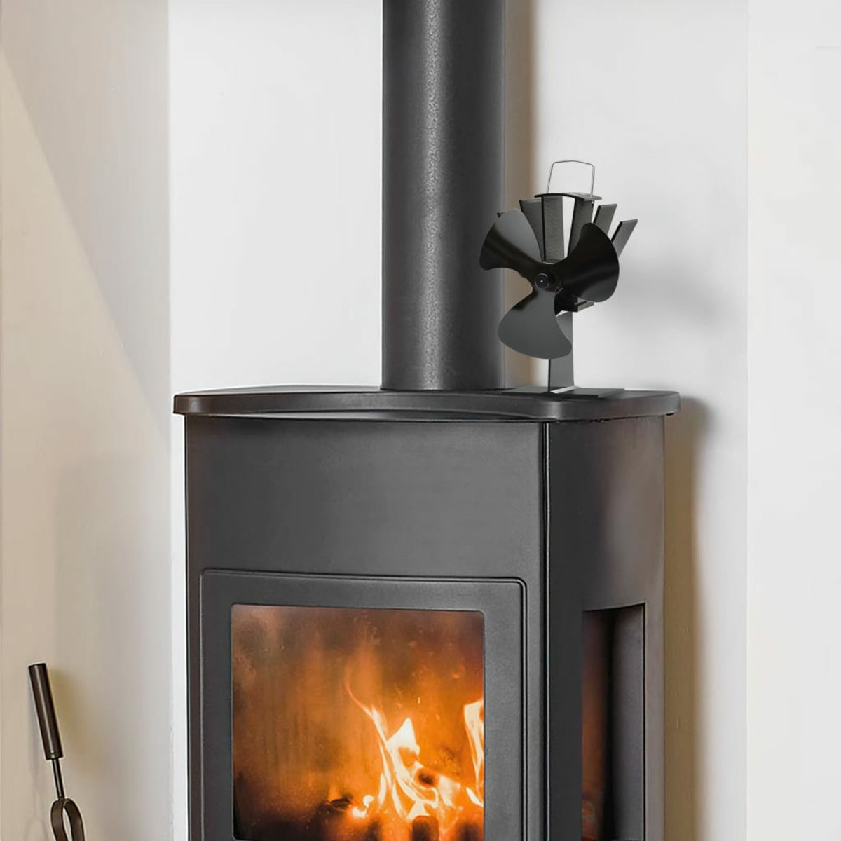 Ein schwarzer Ofen mit Ventilator oben und Feuer darin.