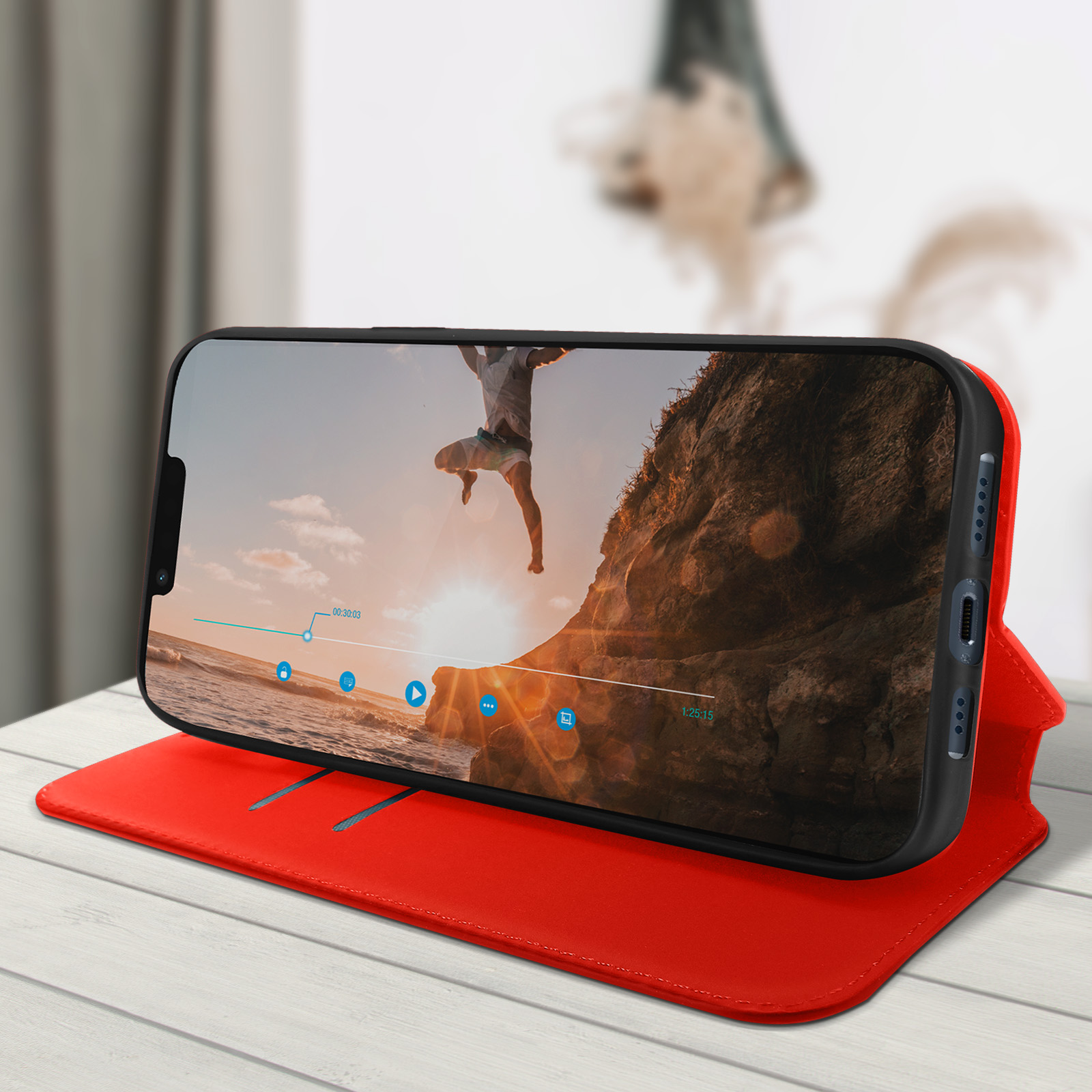 Smartphone op een rode hoes met een video van een man die in het water springt.