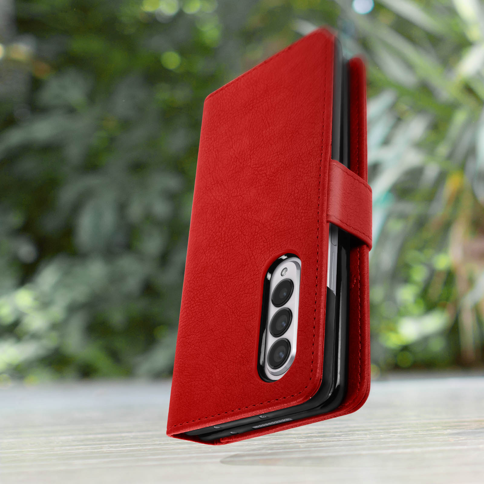 Rote Handyhülle. Die Handyhülle ist mit einem Schnappverschluss geschlossen. Das Telefon befindet sich in der Hülle.