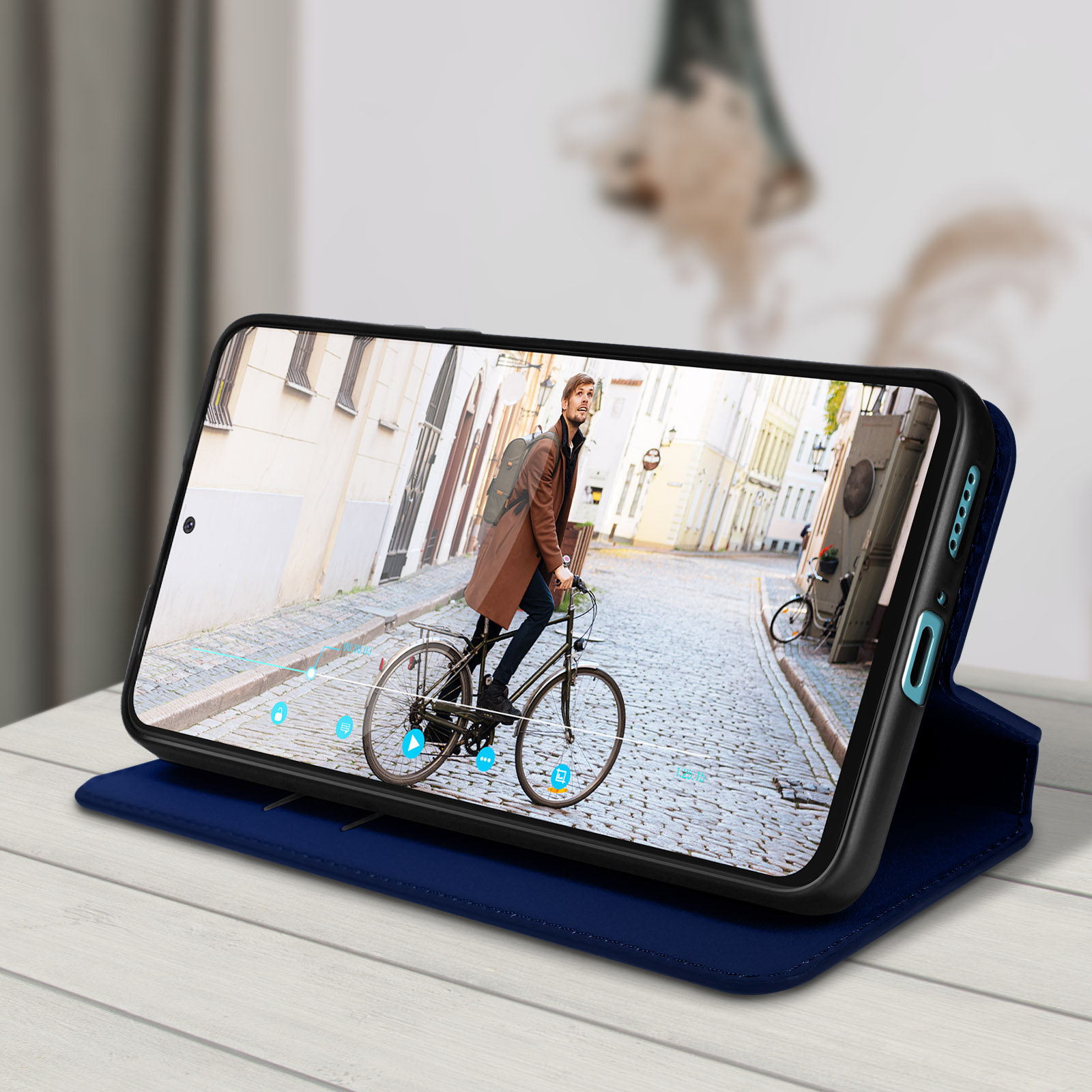 Persona che guarda un video su un telefono in una custodia in pelle blu su un tavolo.