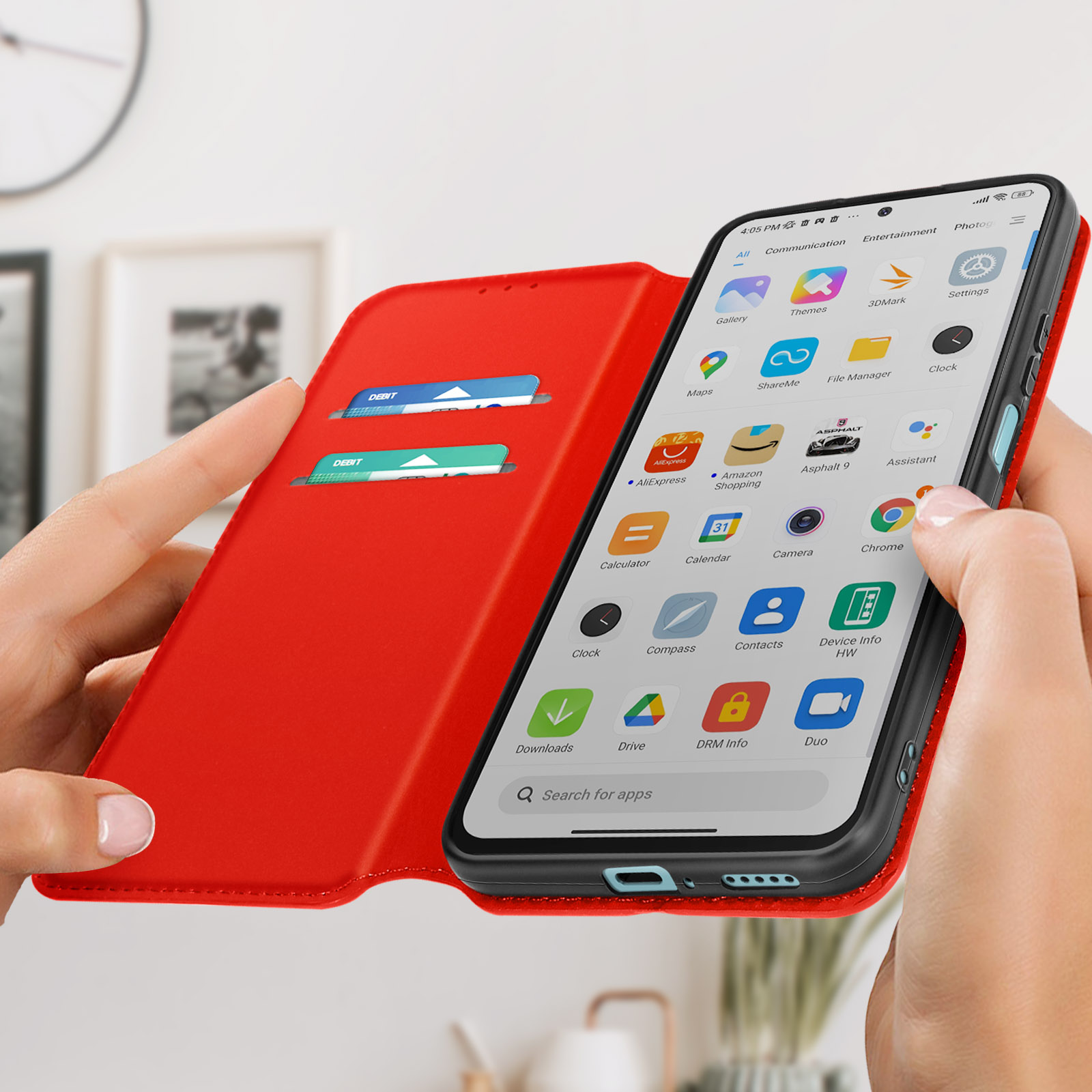Una persona tiene in mano una custodia rossa con un telefono che mostra app e due fessure per carte.