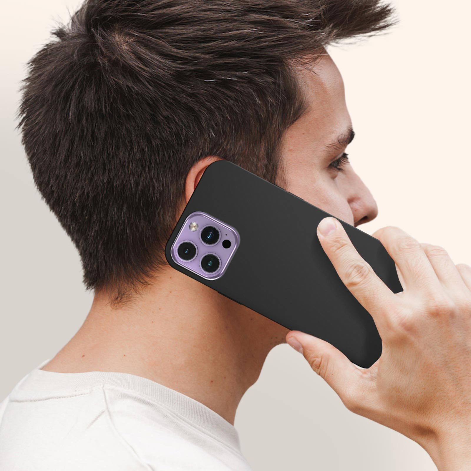 Un uomo che tiene un telefono nero all'orecchio. Il telefono ha un anello fotocamera viola.