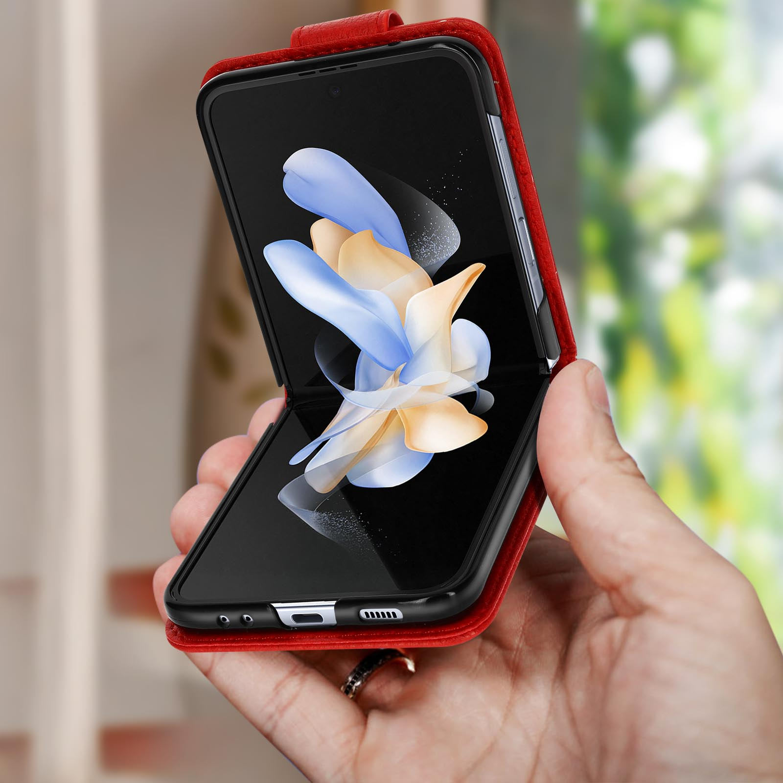 Hand die een rode telefoonhoes vasthoudt. Telefoon binnenin, toont een scherm.