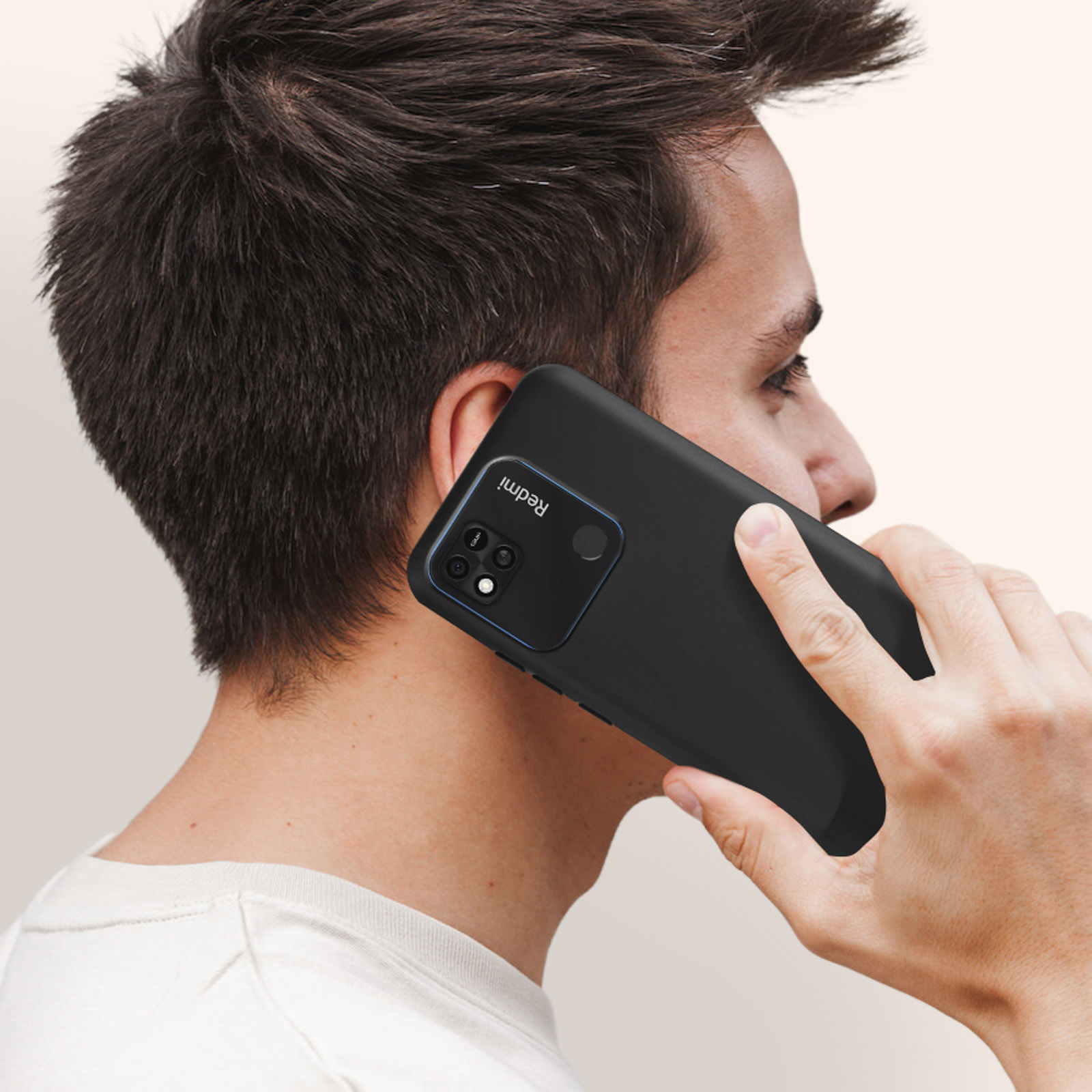 Un uomo tiene un telefono nero all'orecchio. Il telefono ha una fotocamera e il marchio è visibile.