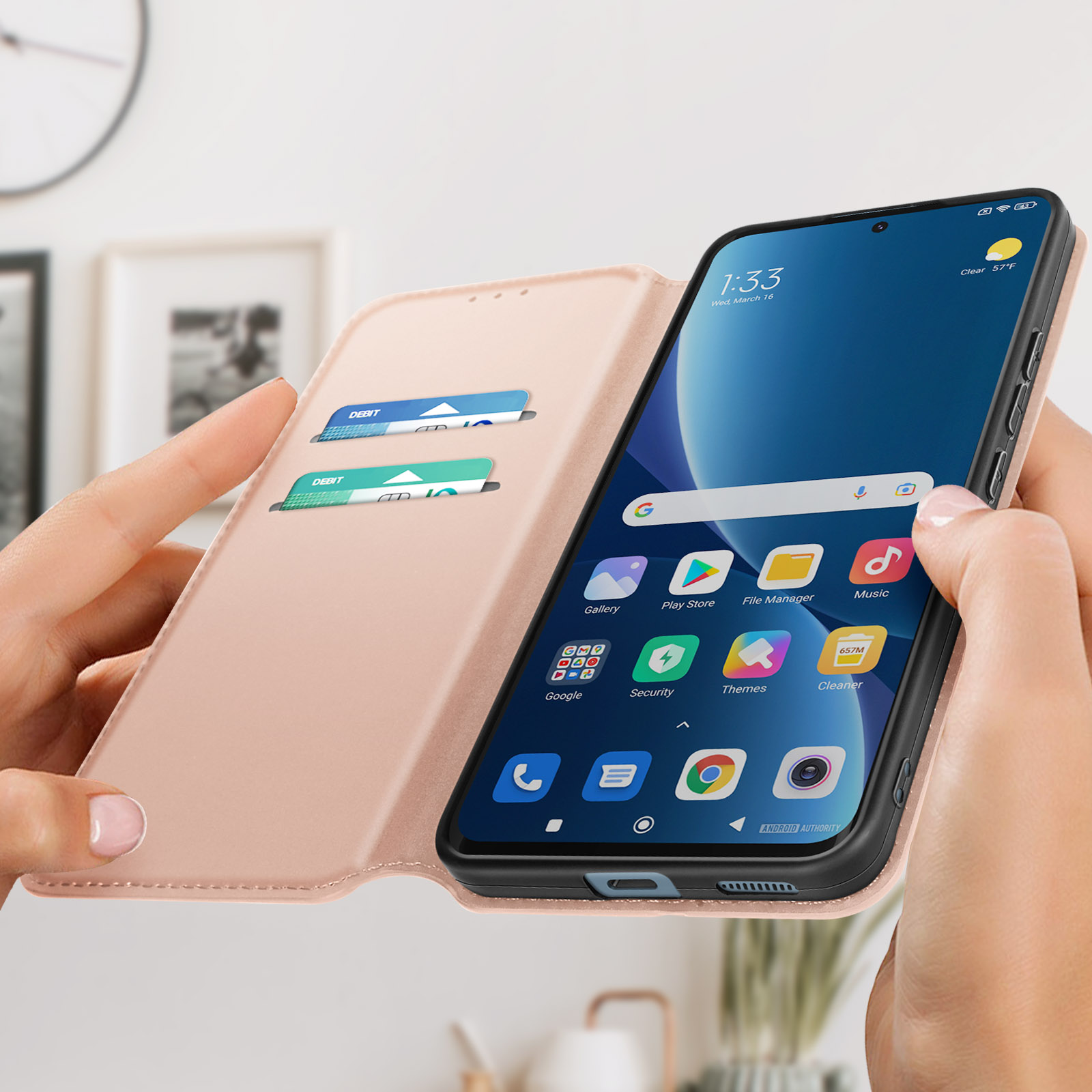 Una persona che tiene una custodia rosa con un telefono dentro, che mostra lo schermo.