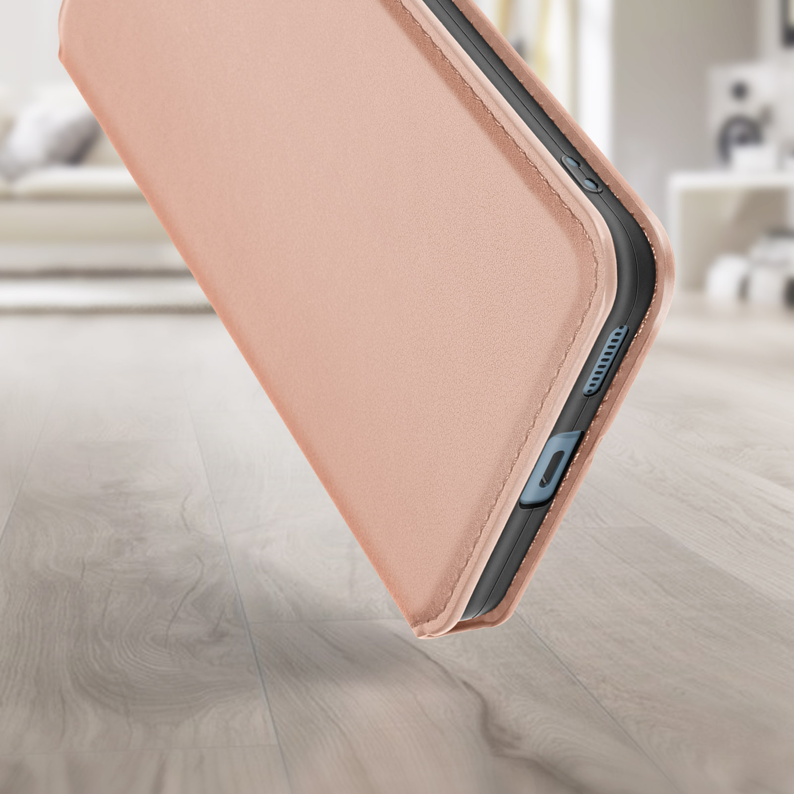 Un primo piano di una custodia per telefono color oro rosa. La custodia è appoggiata su una superficie di legno.