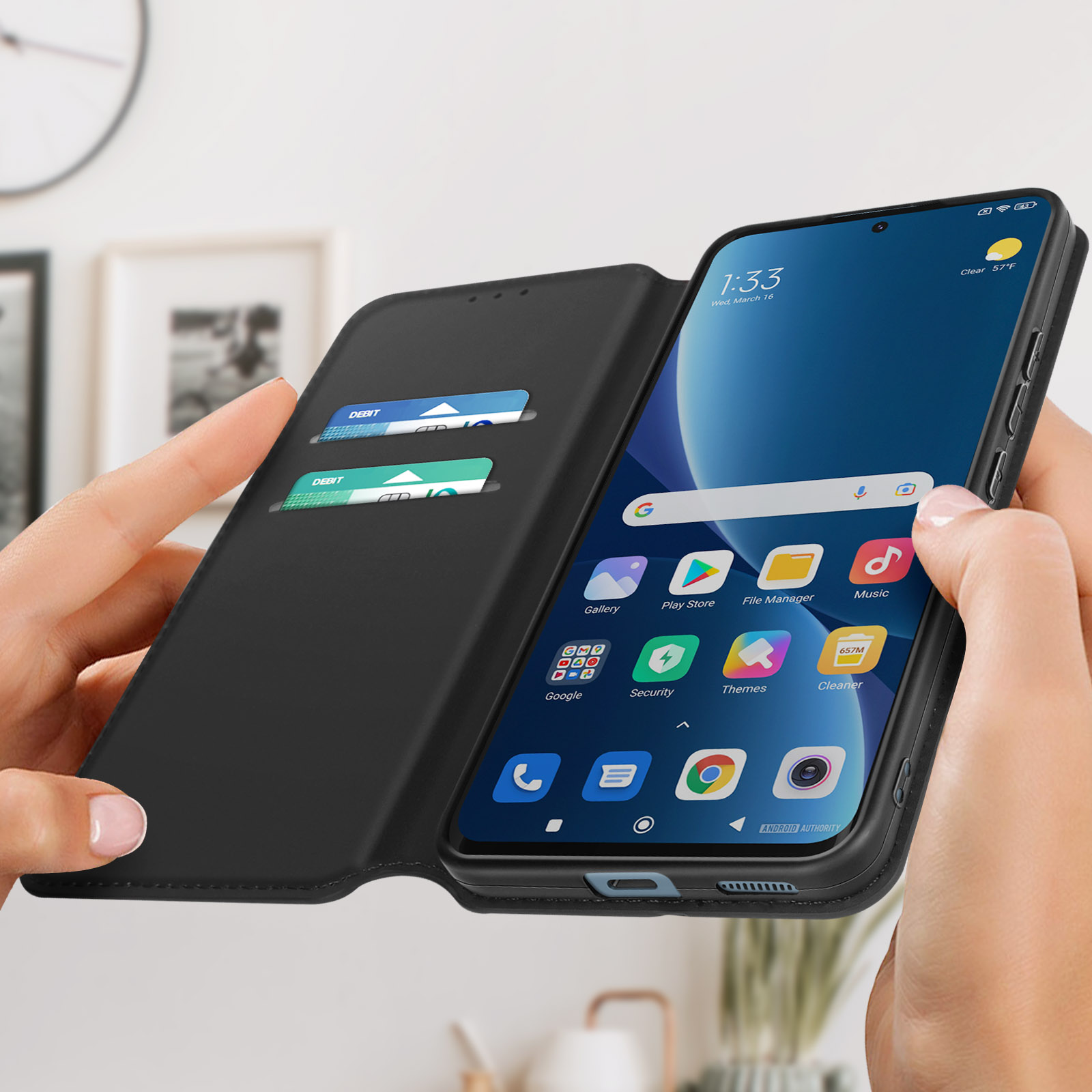 Una persona che tiene un telefono in una custodia nera, mostrando una schermata dell'app. Sfondo sfocato.