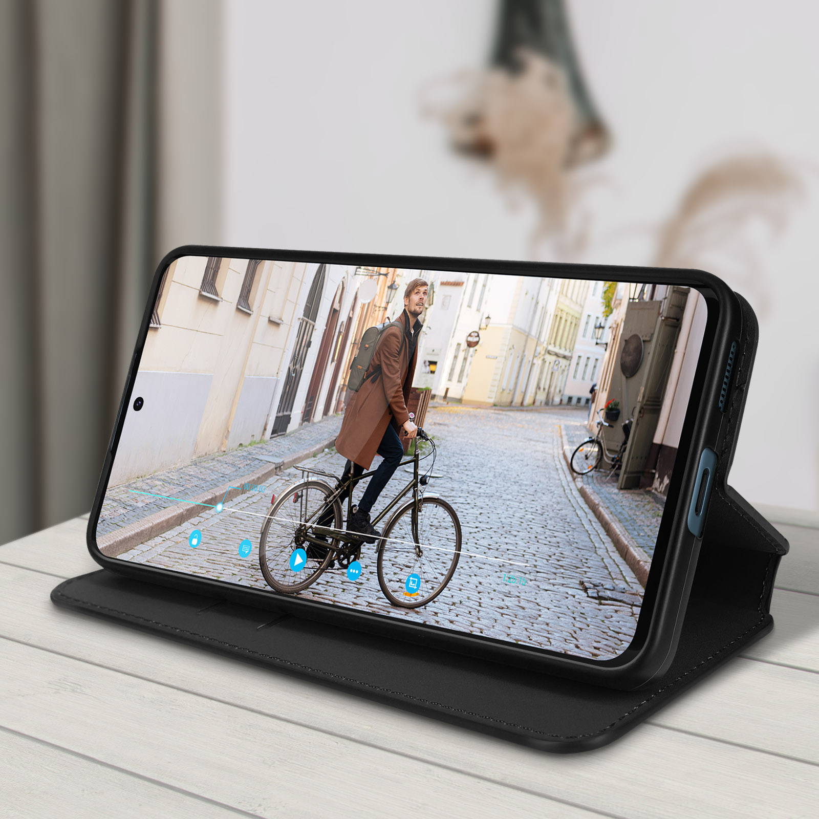 Custodia del telefono che mostra video di uomo in bici su strada acciottolata.