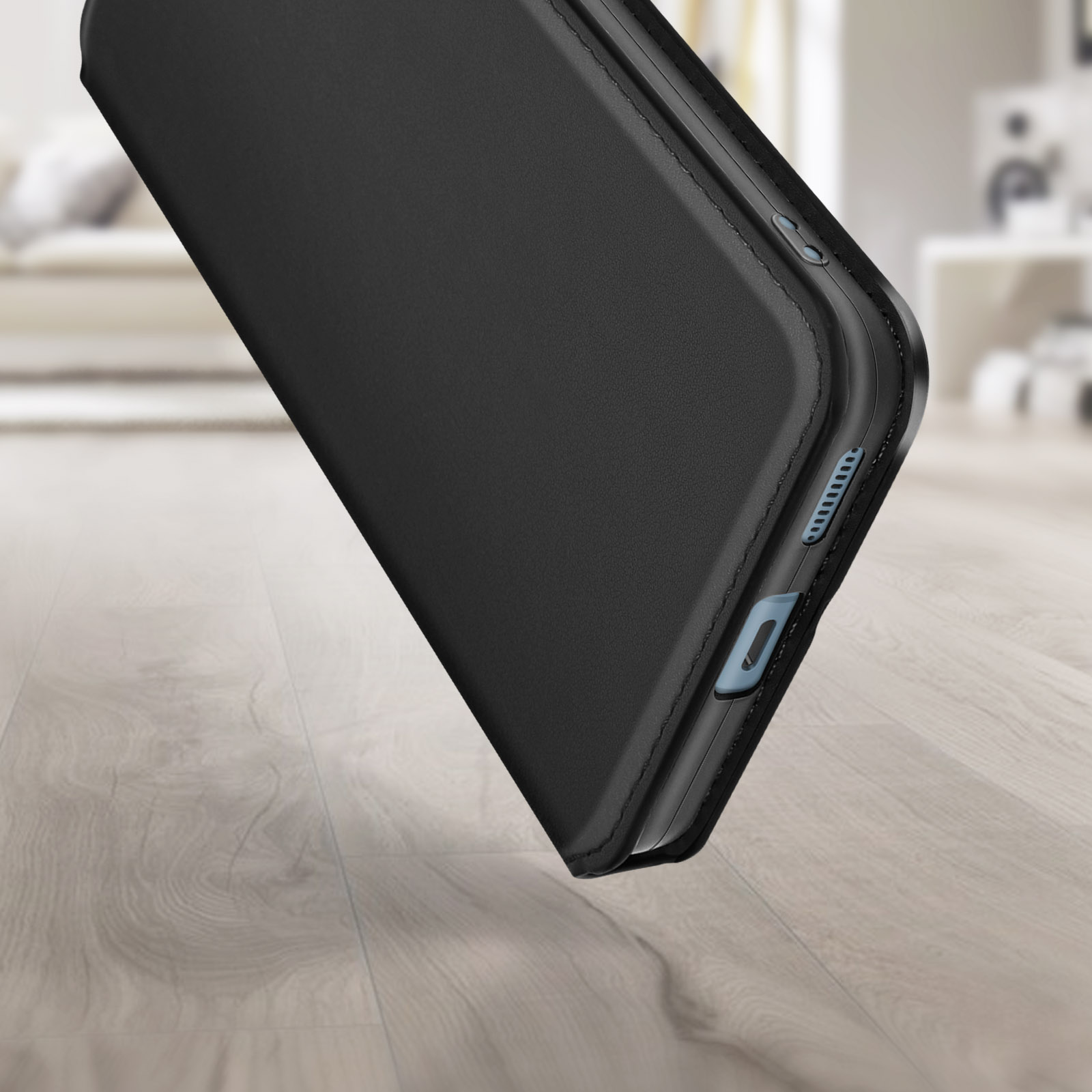 Primo piano di una custodia nera per telefono, angolata su un pavimento in legno. La custodia è nero pieno.
