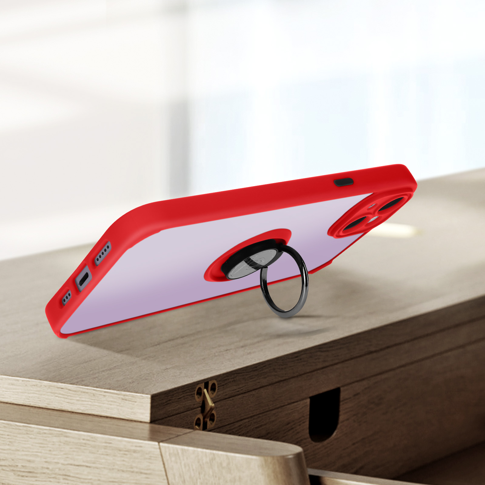 Un étui de téléphone rouge avec un support de bague, sur une surface en bois. Le téléphone est visible.