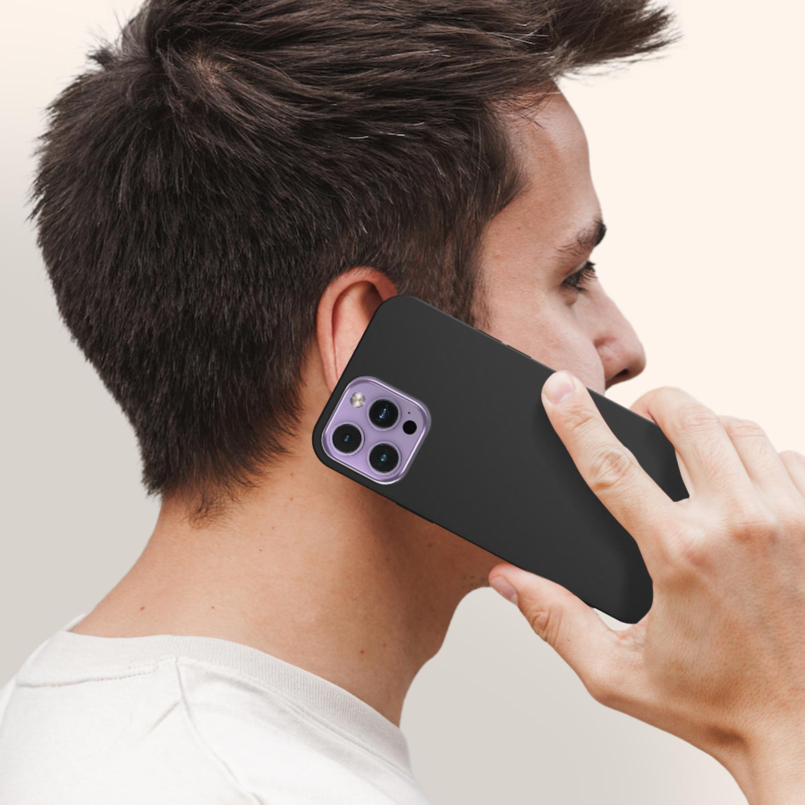 Homme tenant un téléphone noir avec une caméra violette. Il porte un t-shirt blanc.