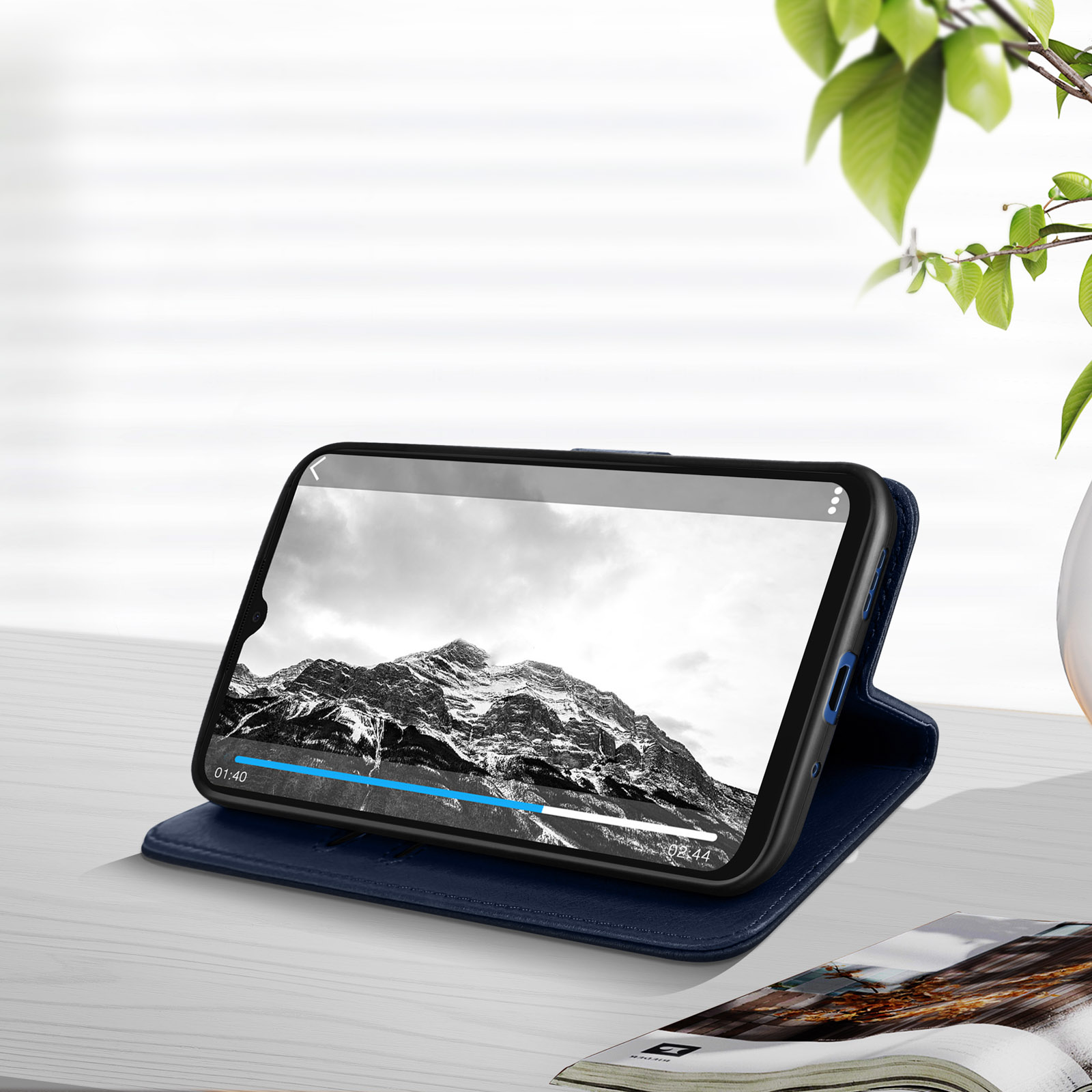 Uno smartphone in una custodia blu, che mostra un video di un paesaggio montano.