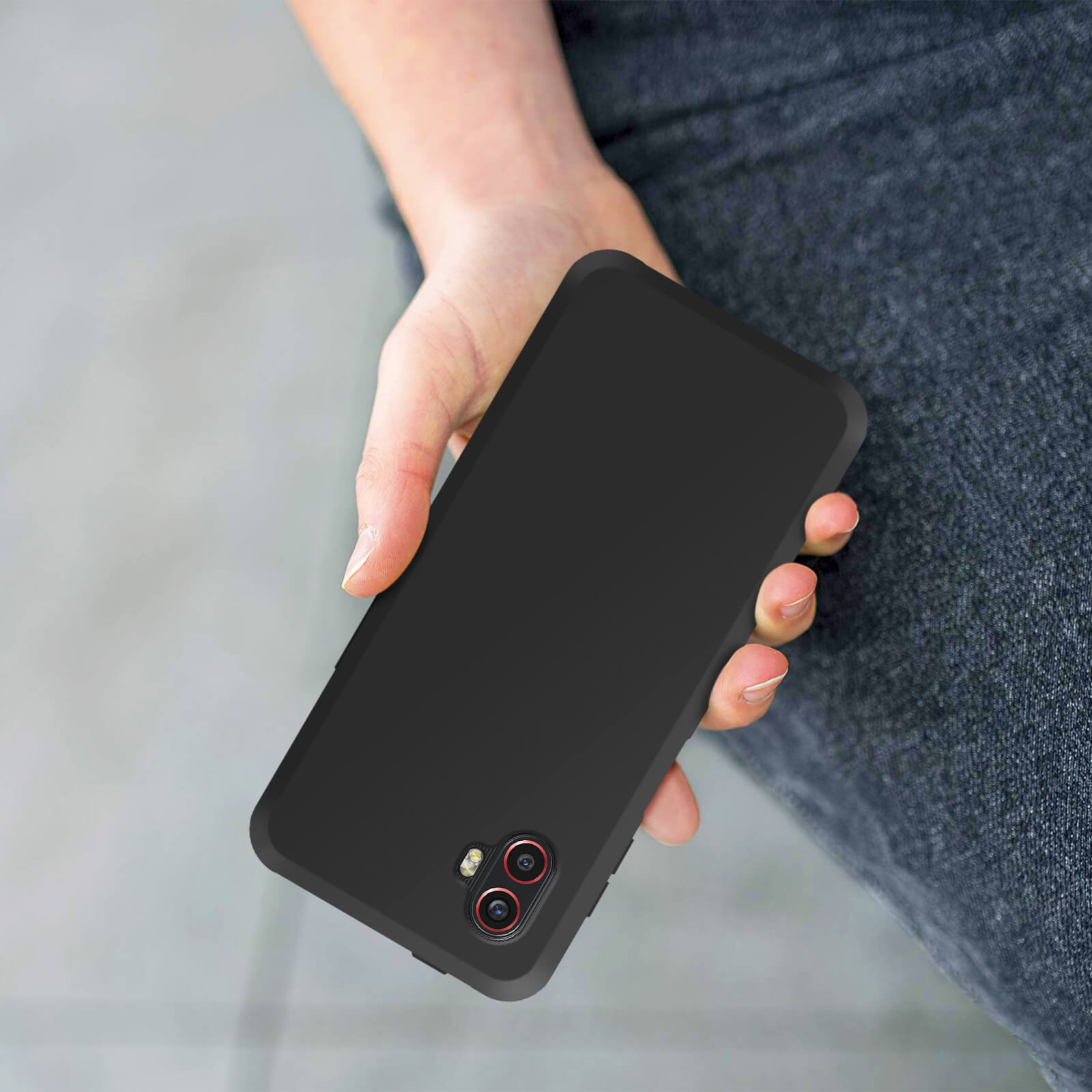 Een persoon die een zwarte telefoonhoes vasthoudt. De hoes heeft twee camera-openingen.