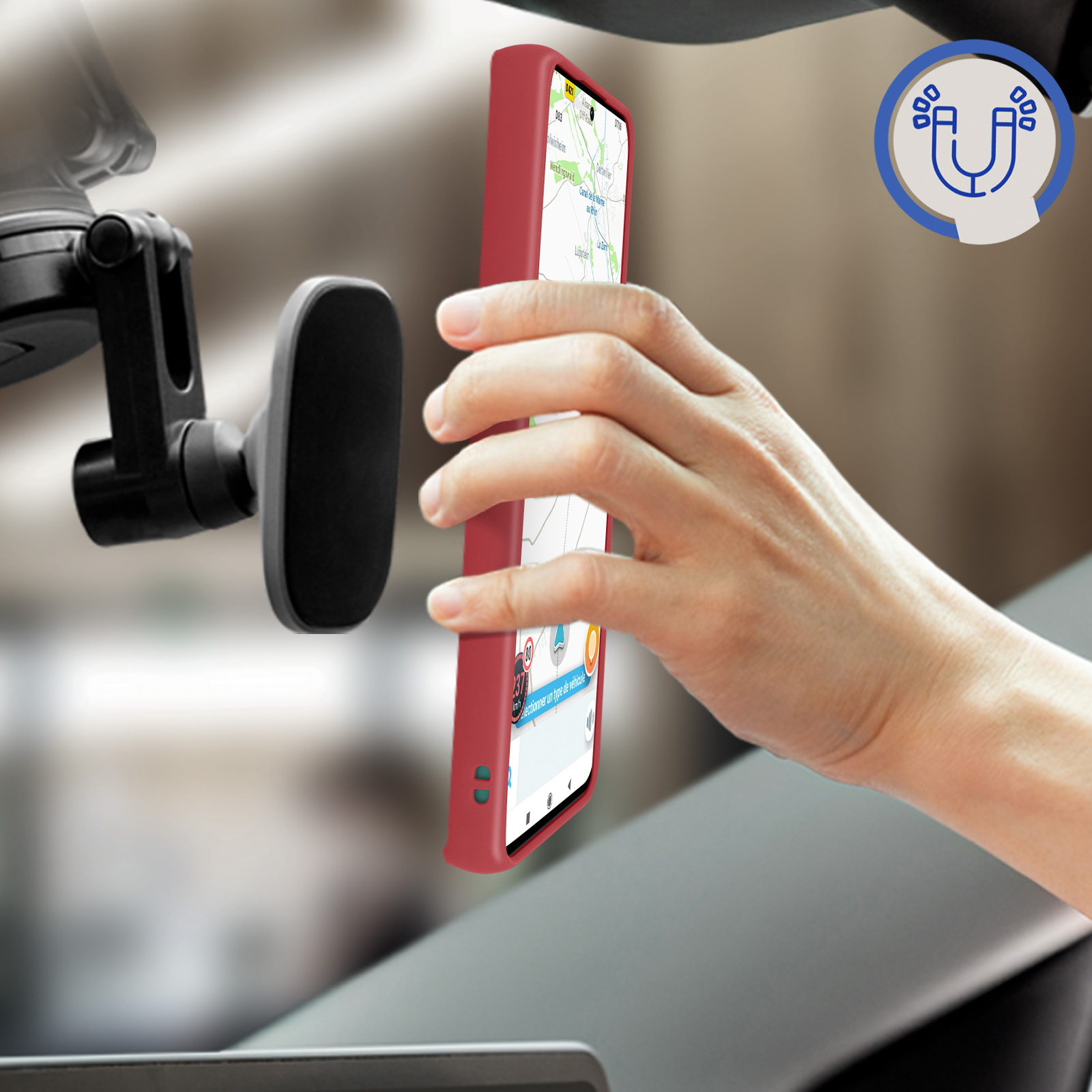 Mano che tiene custodia rossa in auto. Telefono mostra mappa. Supporto magnetico a sinistra.