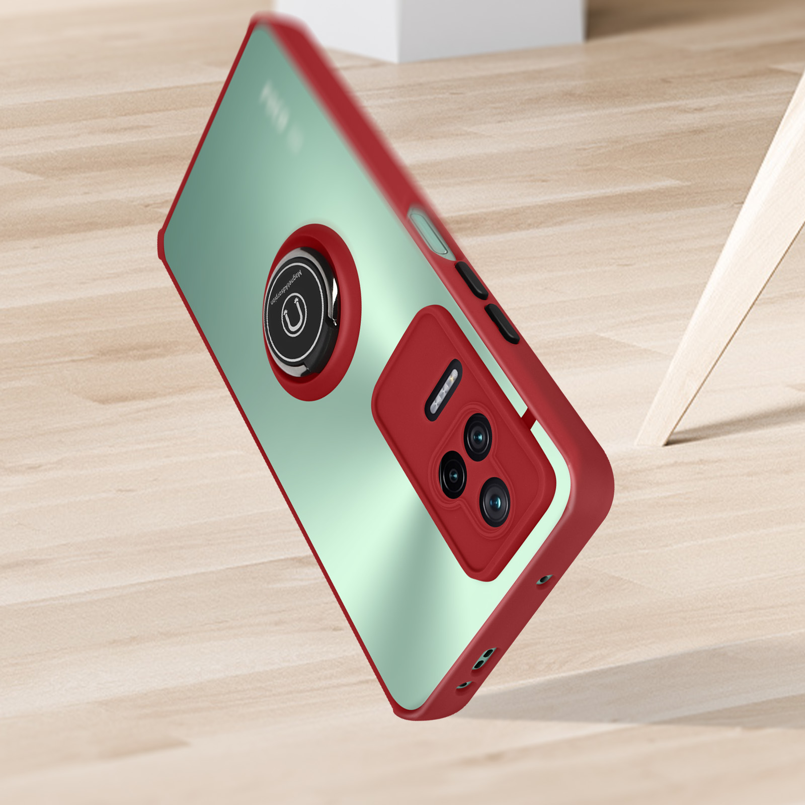 Custodia per telefono rossa con un supporto ad anello. Il telefono è su una superficie di legno. Le lenti della fotocamera sono visibili.