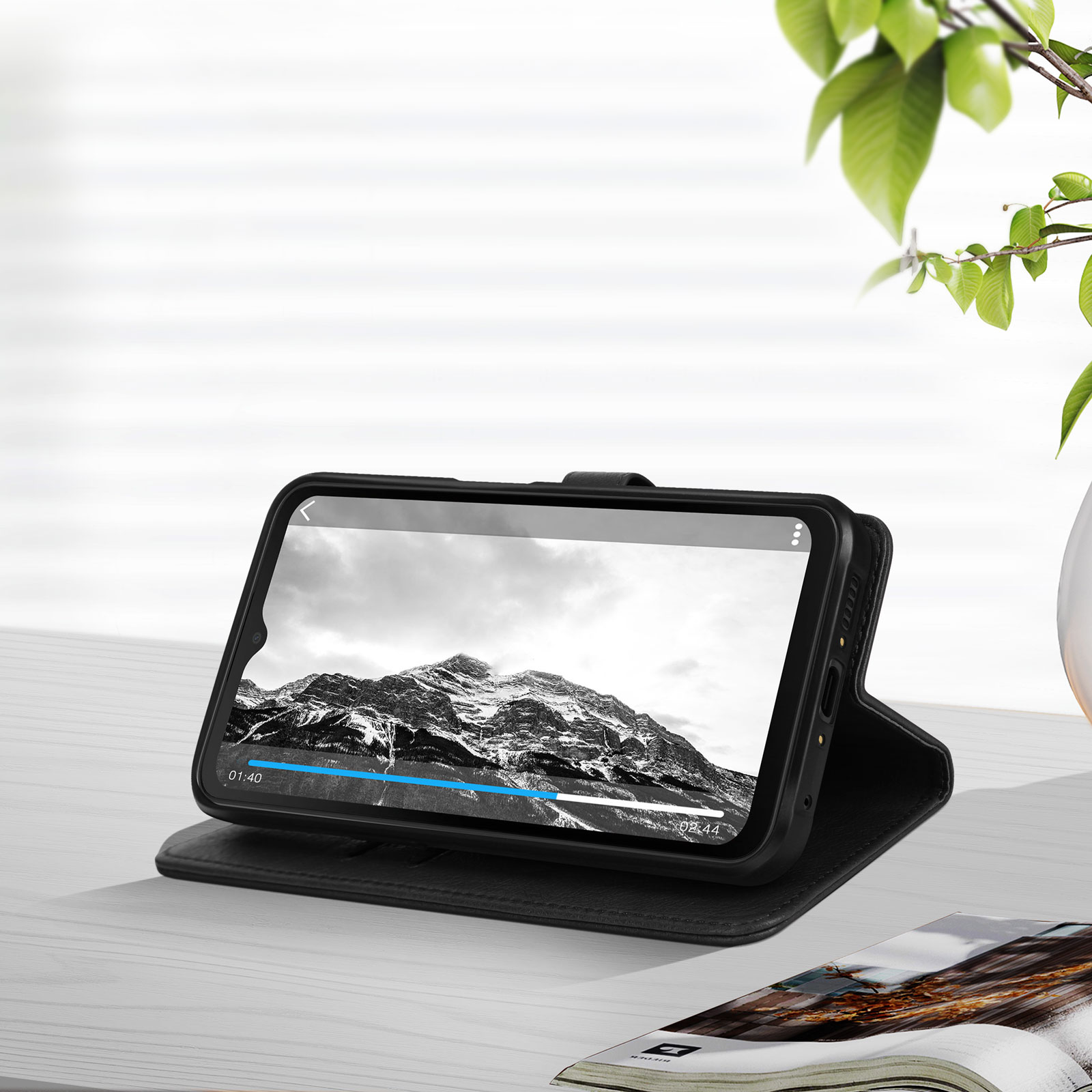 Smartphone in een zwarte hoes die een landschapsvideo toont, op een houten oppervlak.